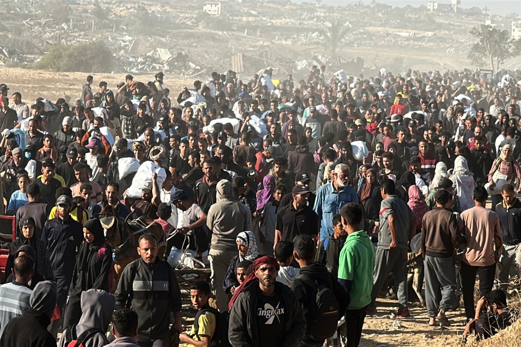 Crowds of Palestinians carry food relief items in Gaza City on May 29, 2025.