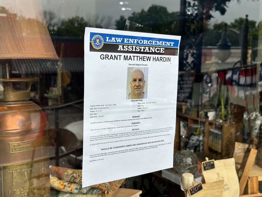 A flier seeking ex-police chief Grant Hardin hangs on a business window in downtown Calico Rock, Arkansas.