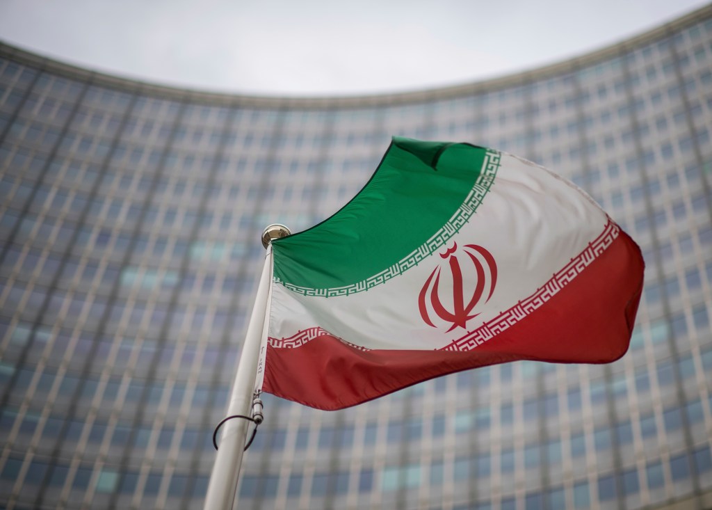 A national flag of Iran waves in front of the building of the International Atomic Energy Agency, IAEA, in Vienna, Austria, Friday, Dec. 17, 2021.