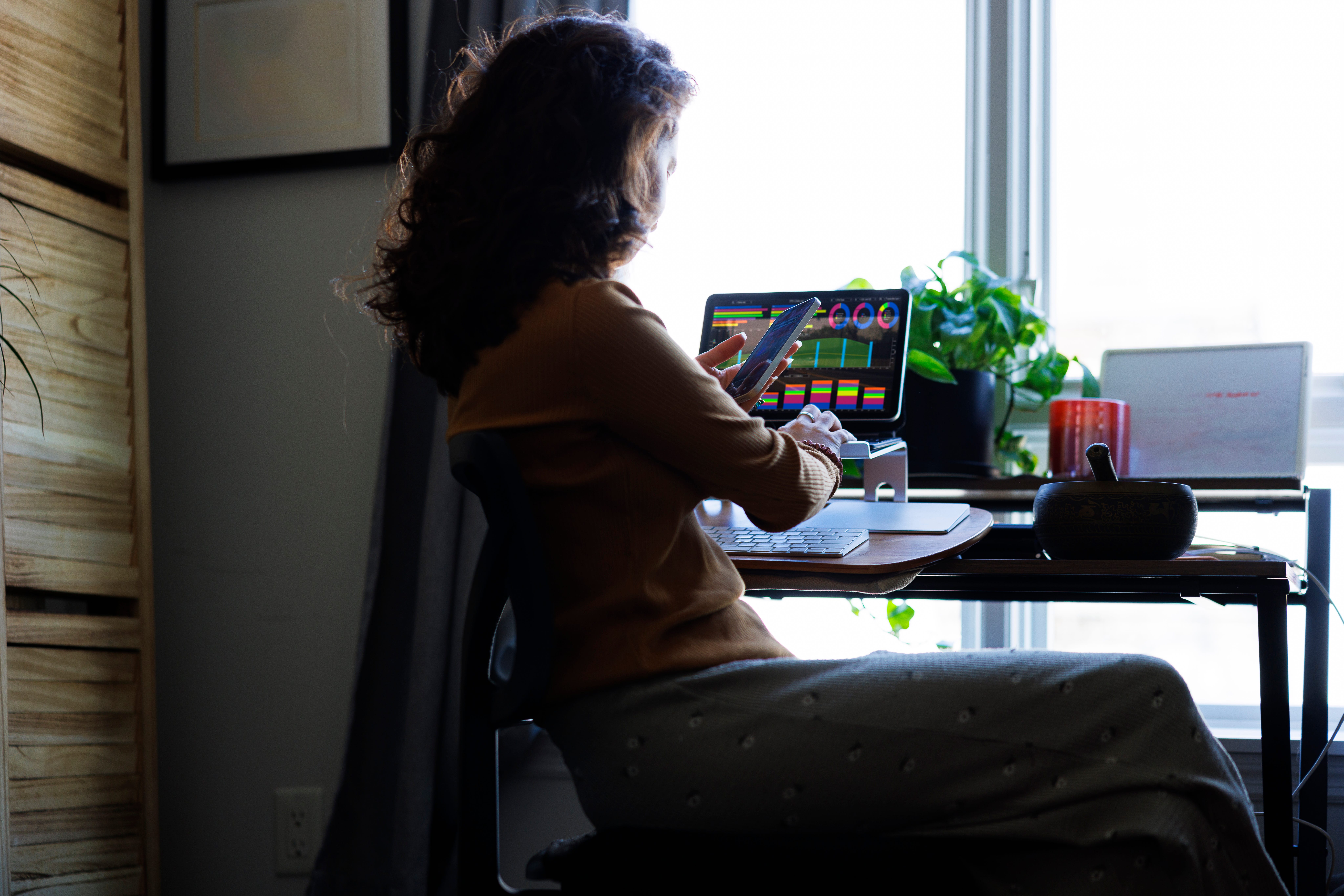 A woman sits in a desk working on a computer.