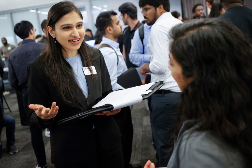 A hiring person looks at a person at a hiring fair