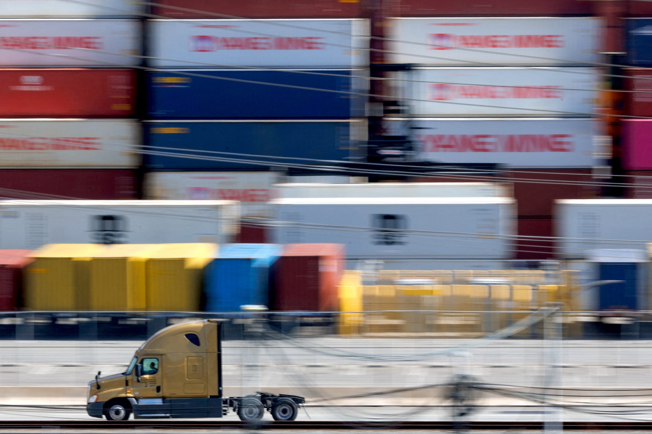 A vehicle drives past shipping containers from China, at the China Shipping (North America) Holding Company Ltd. facility at the Port of Los Angeles on February 4, 2025.