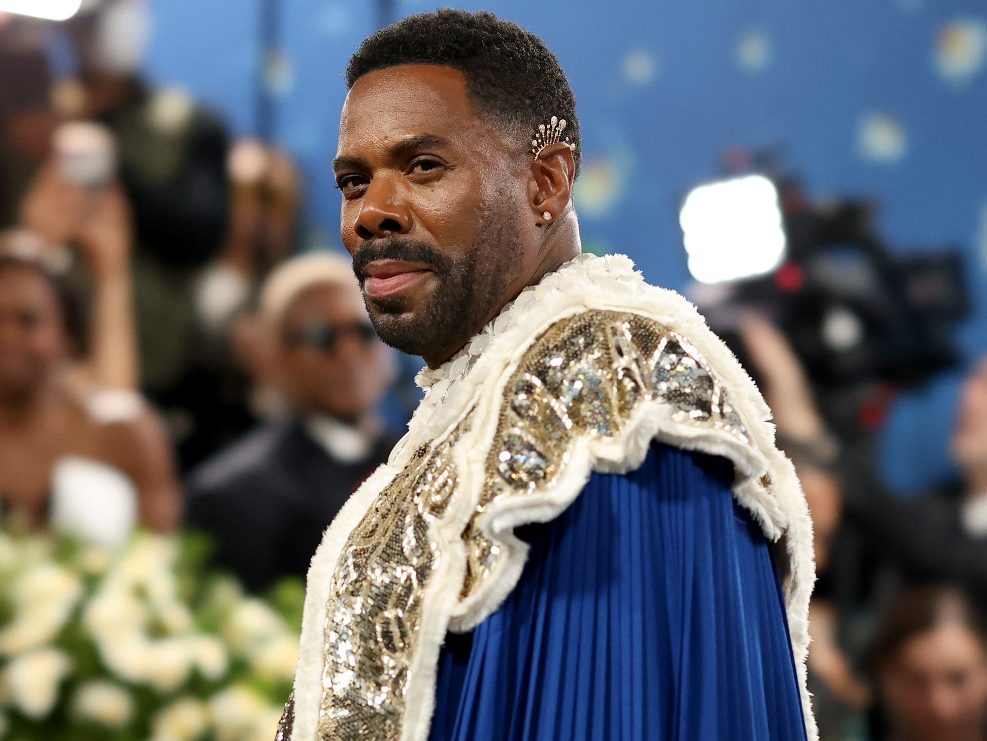 Colman Domingo poses at the Met Gala while wearing a pleated blue cape with a beaded chest piece.