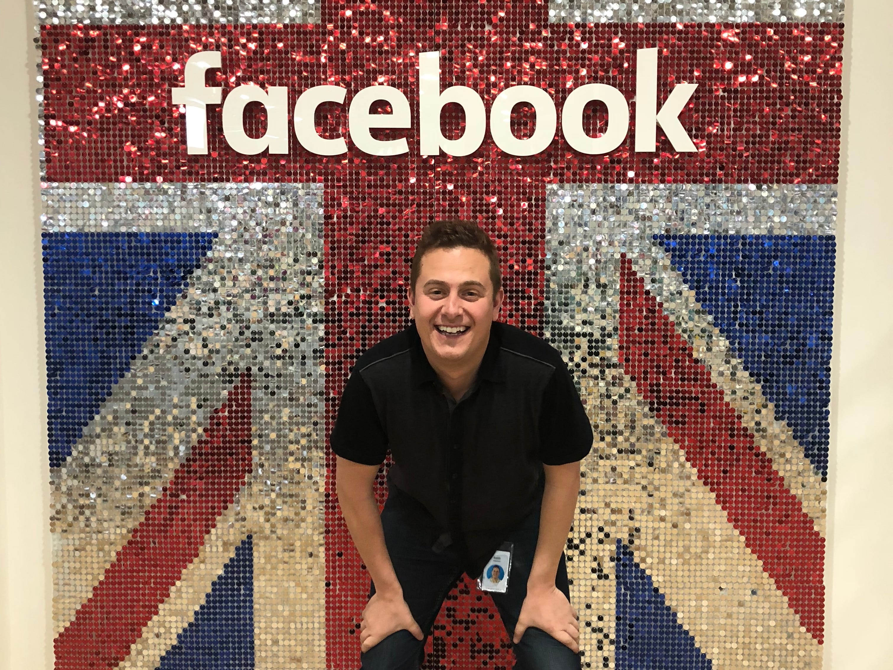 a man stands in front of a British flag that says Facebook