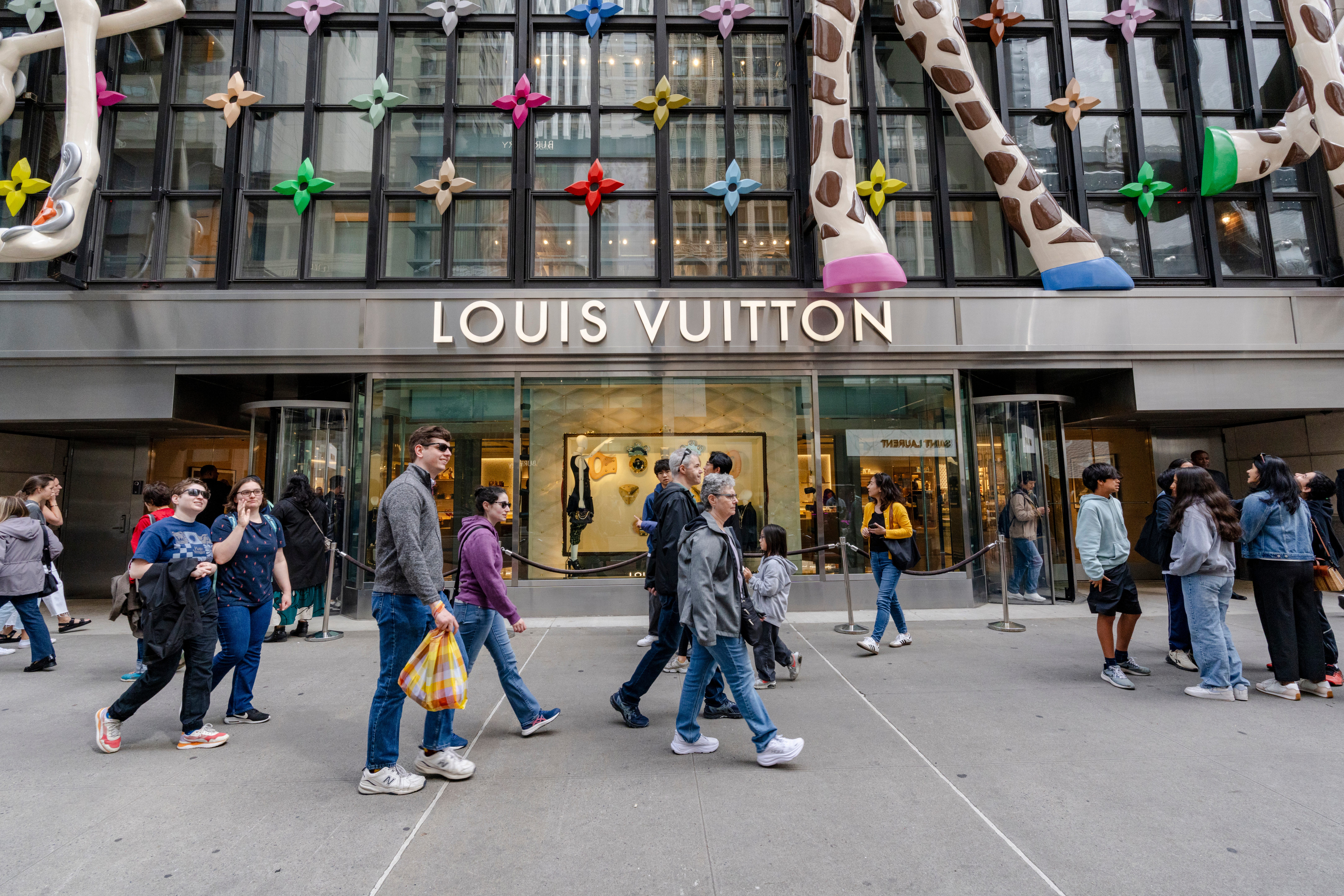 People walk by the Louis Vuitton store during Memorial Day weekend on May 25, 2025 in New York City. (