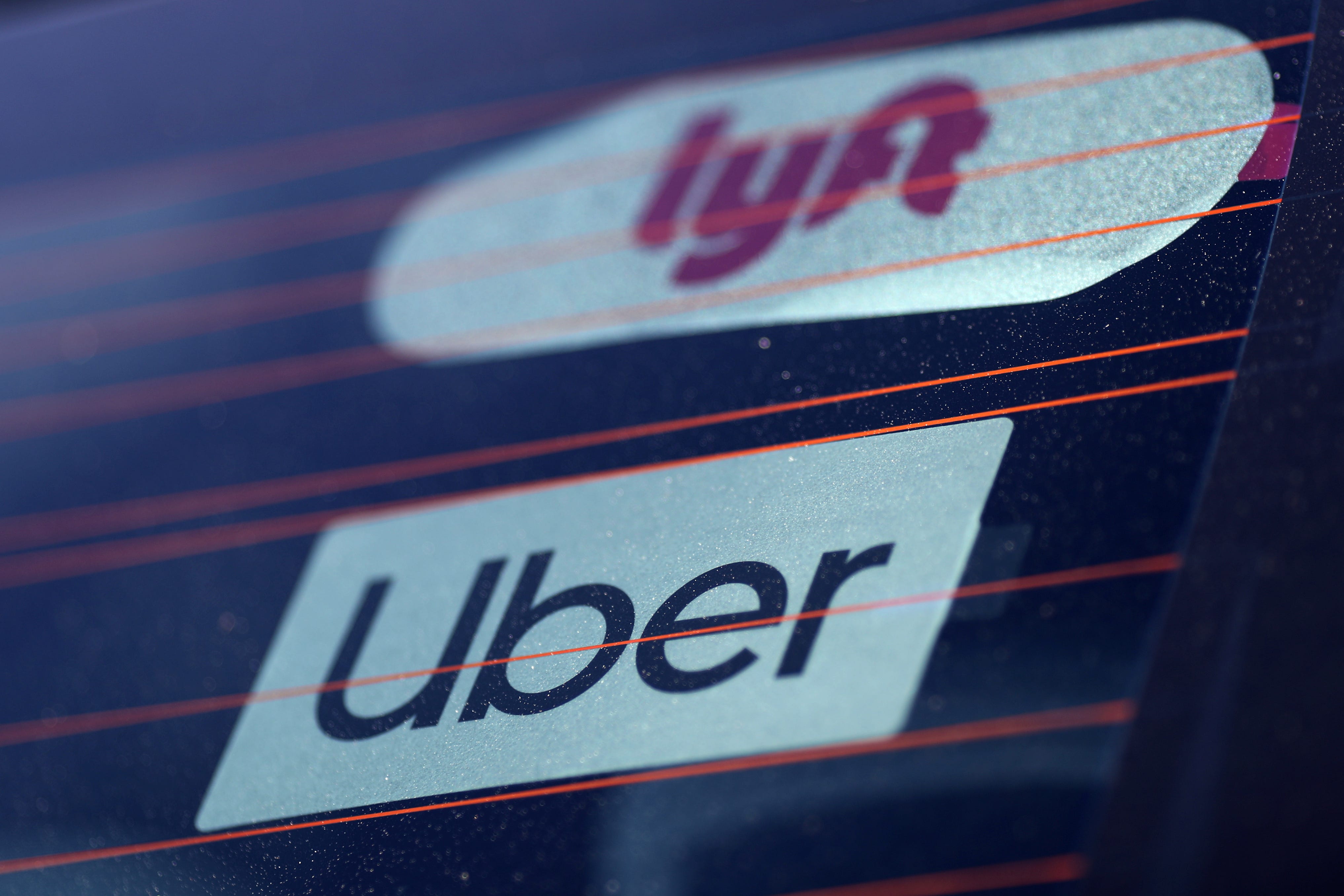 Uber and Lyft signs are seen on a car in Redondo Beach, California, U.S., March 25, 2019. REUTERS/Lucy Nicholson