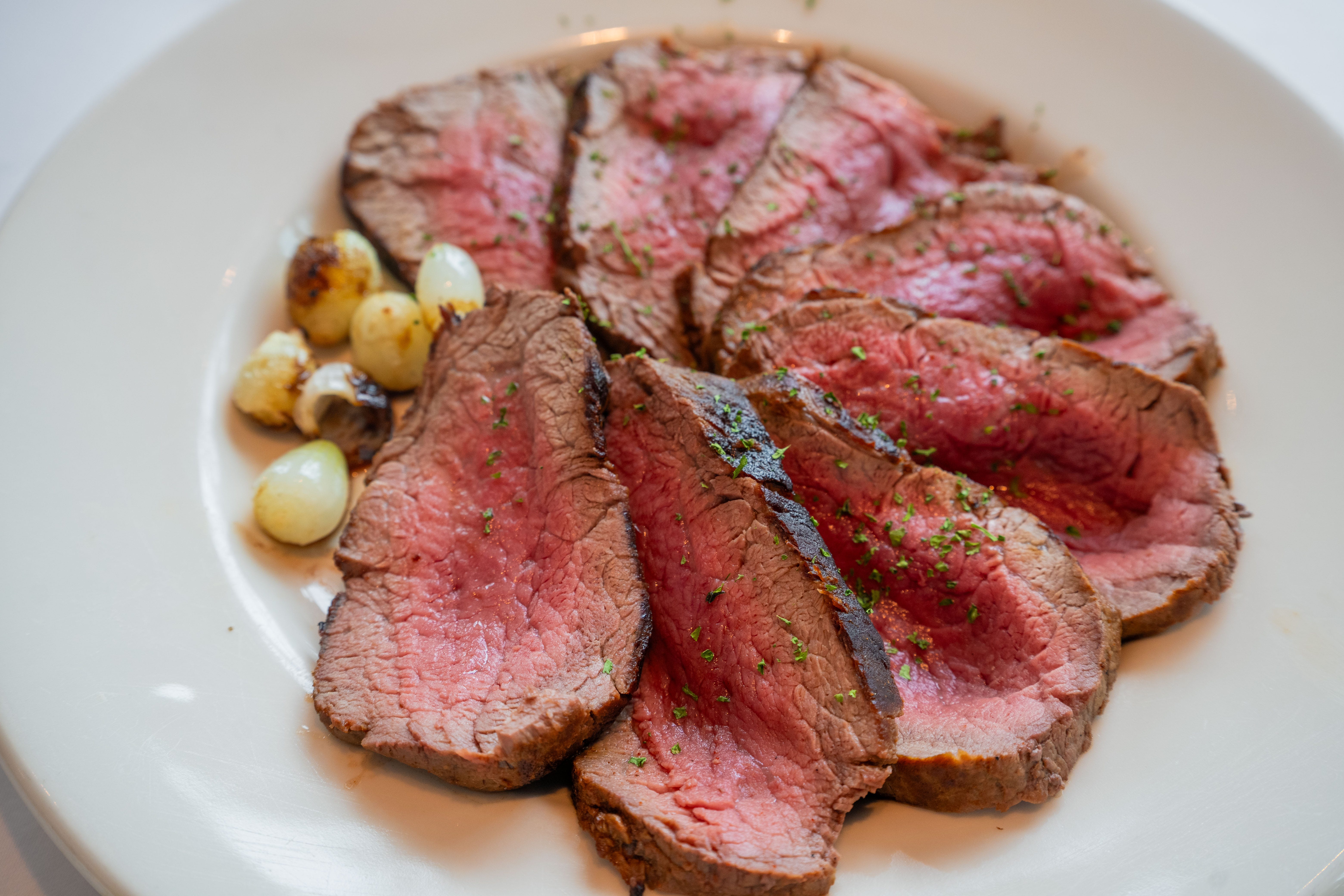 Sliced pink-center steak on a plate in a circle