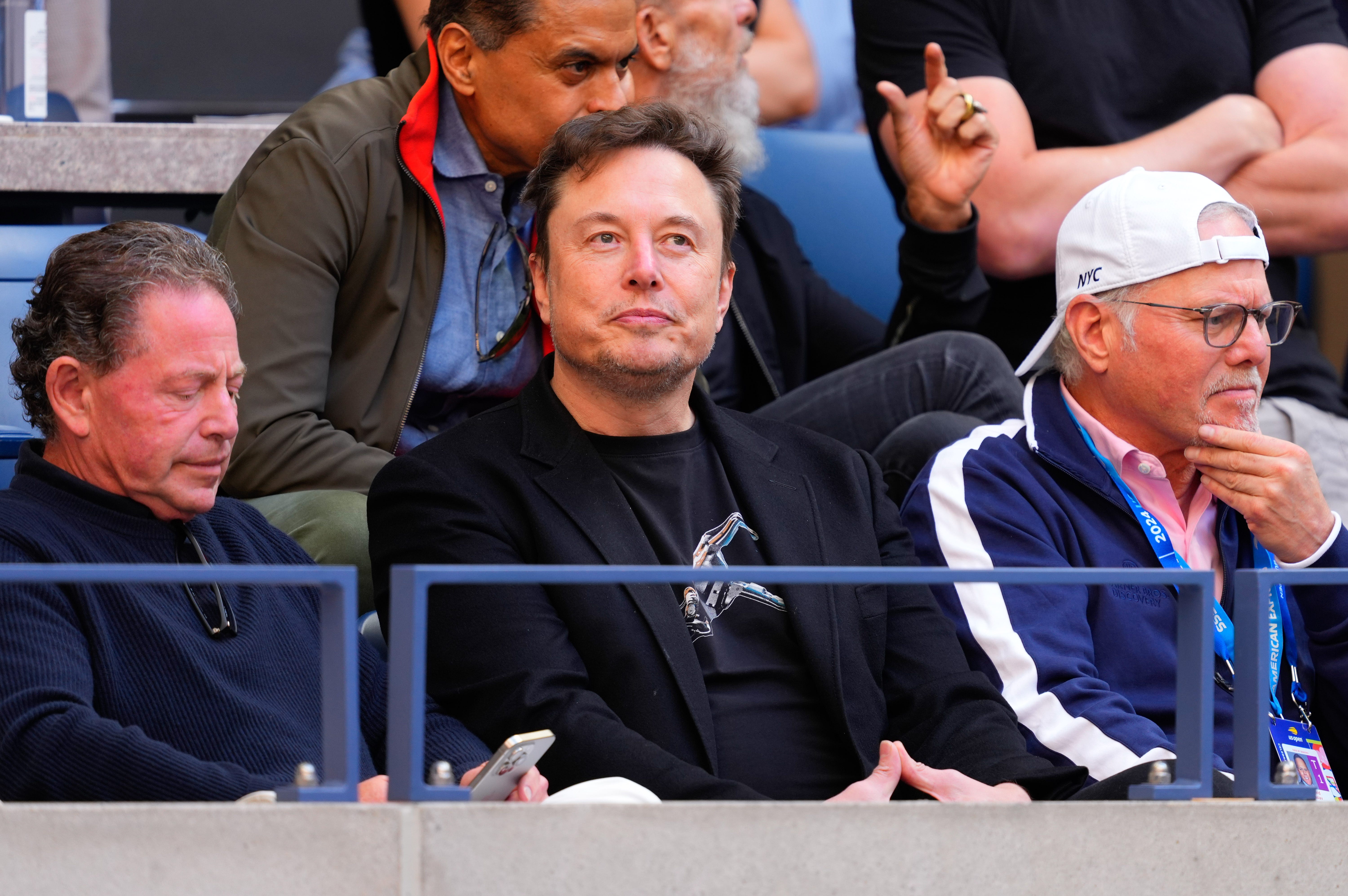Elon Musk attended the men's singles final of the US Open in a black blazer layered over a black graphic tee.