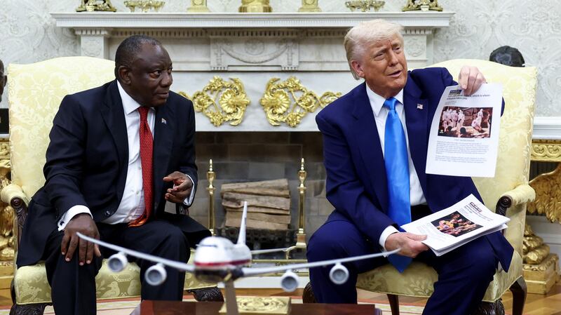 U.S. President Donald Trump shows alleged news reports as he meets South African President Cyril Ramaphosa in the Oval Office of the White House in Washington, D.C., U.S., May 21, 2025.