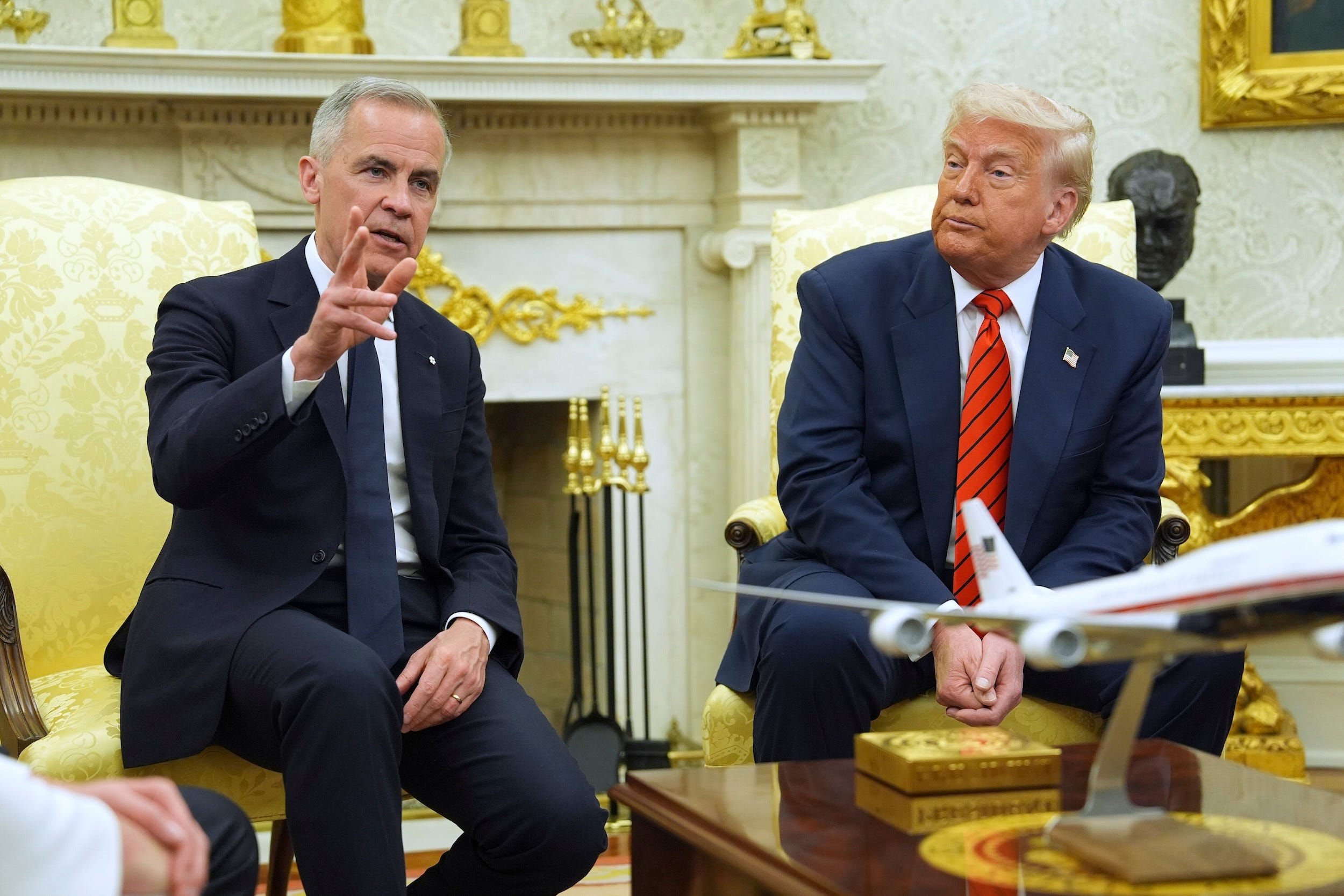 Donald Trump looks at Mark Carney during a meeting in the Oval Office