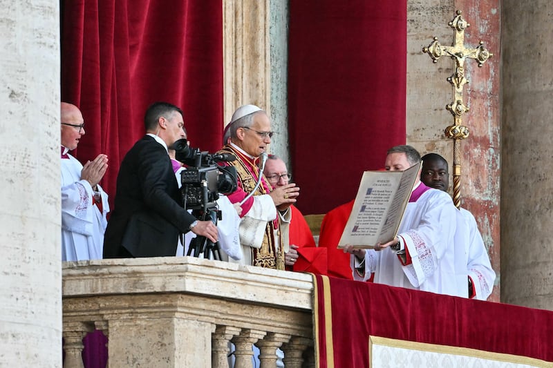 Newly elected Pope Leo XIV, Robert Prevost (C) gestures on the main central loggia balcony of the St Peter's Basilica for the first time, after the cardinals ended the conclave, in The Vatican, on May 8, 2025.