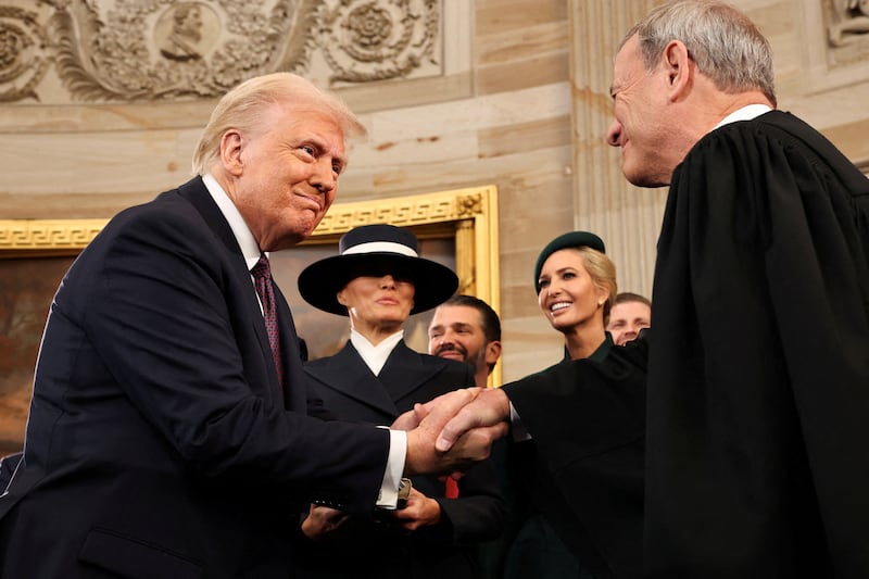 U.S. President Donald Trump shakes hands with U.S. Supreme Court Chief Justice John Roberts (R) as Melania Trump, Donald Trump Jr. and Ivanka Trump look on after being sworn in during inauguration ceremonies in the Rotunda of the U.S. Capitol on January 20, 2025 in Washington, DC.