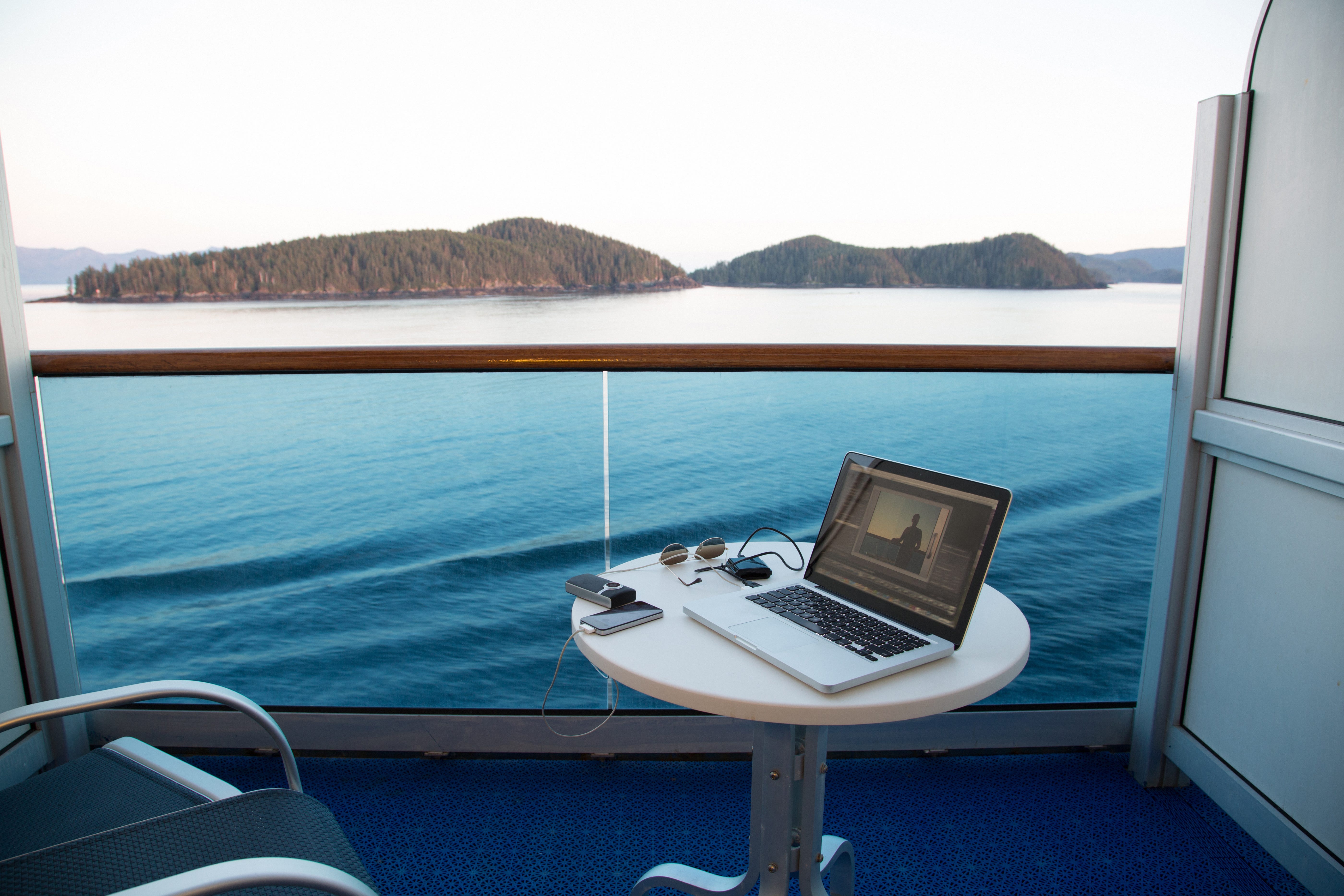 A laptop sits on a table in cruise ship balcony.