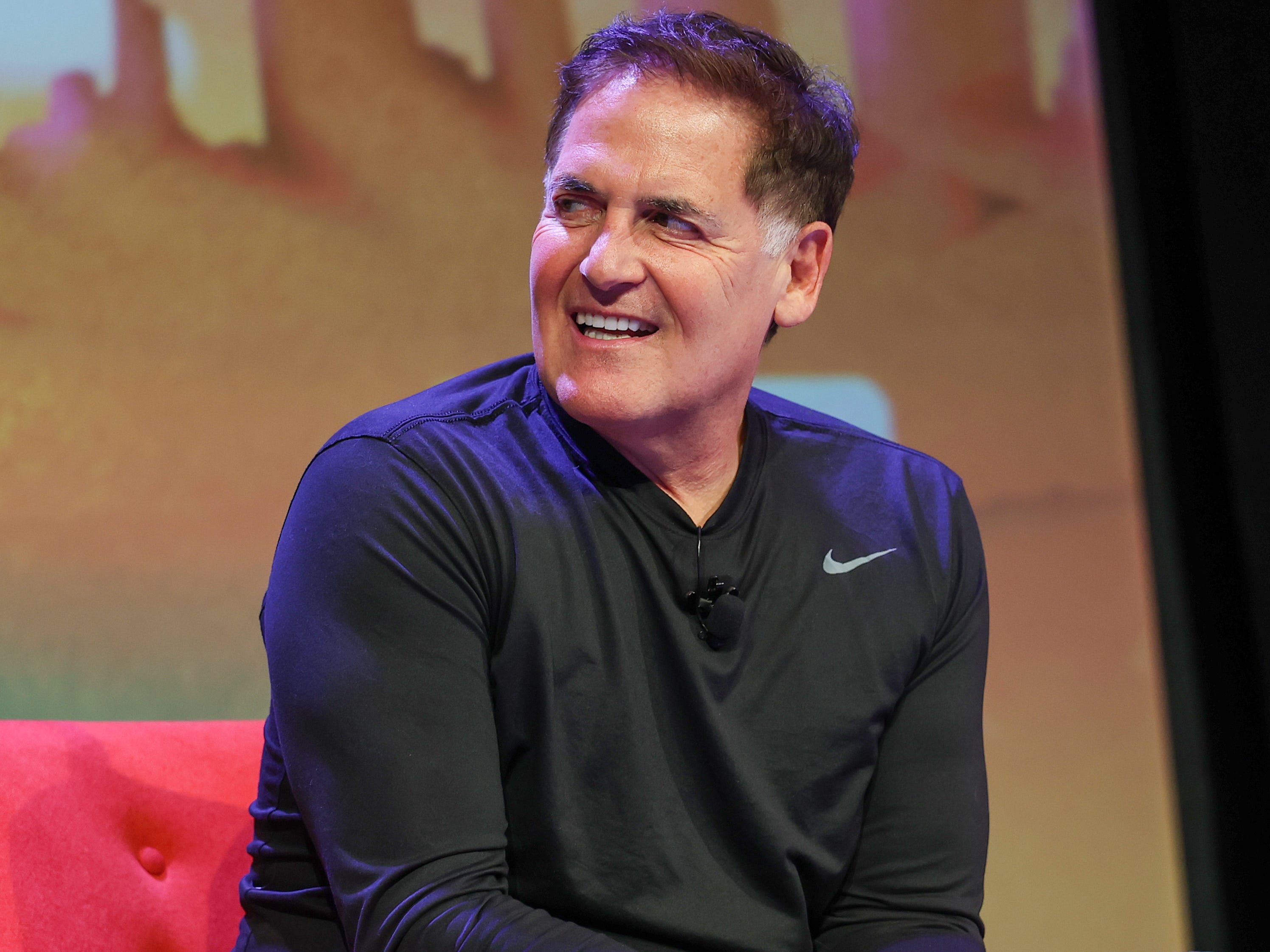 Mark Cuban sitting in a red sofa.