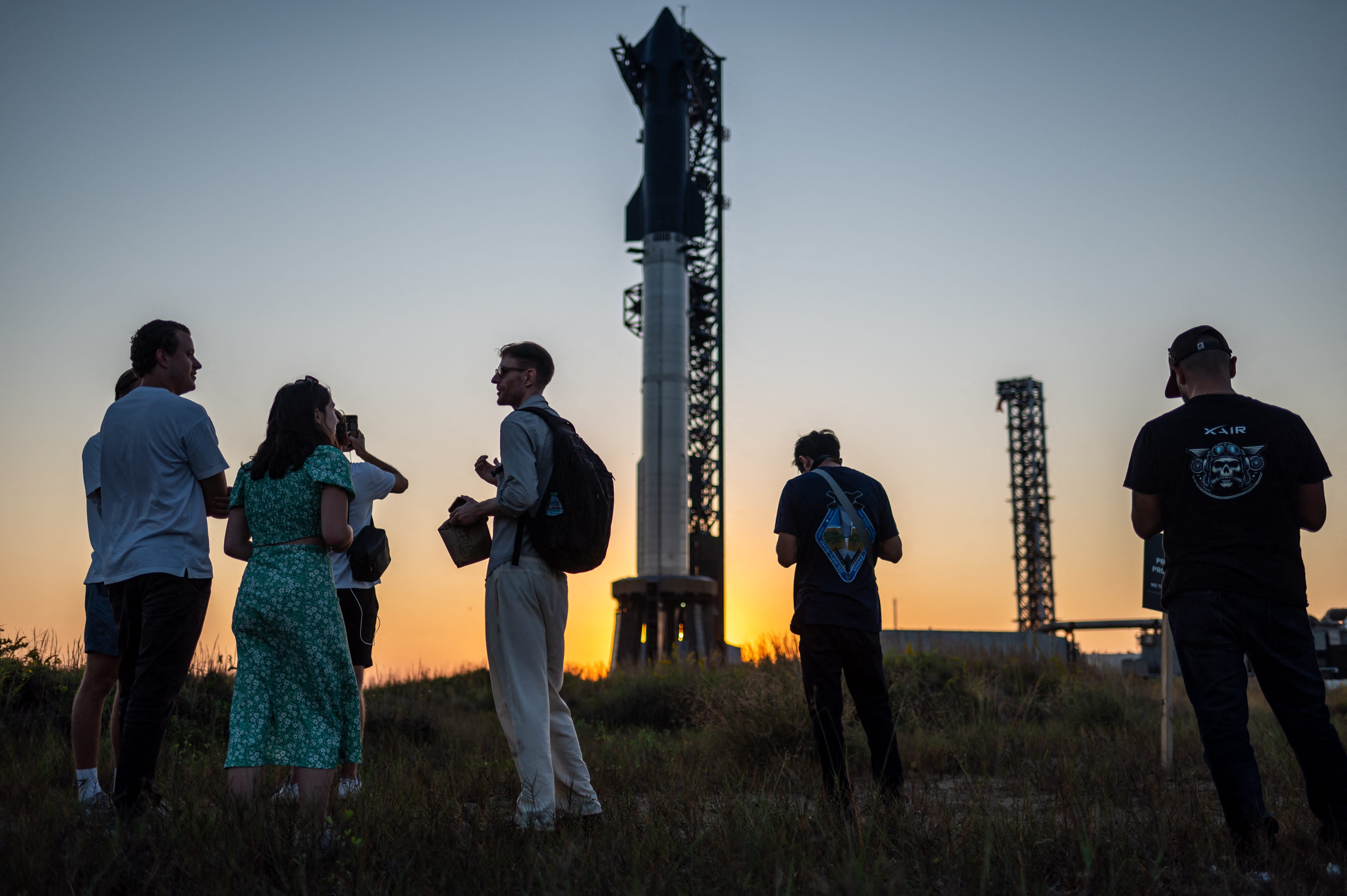 Visitors look at the SpaceX Starship as it sits on a launch pad at Starbase near Boca Chica, Texas, ahead of the Starship Flight 5 test.