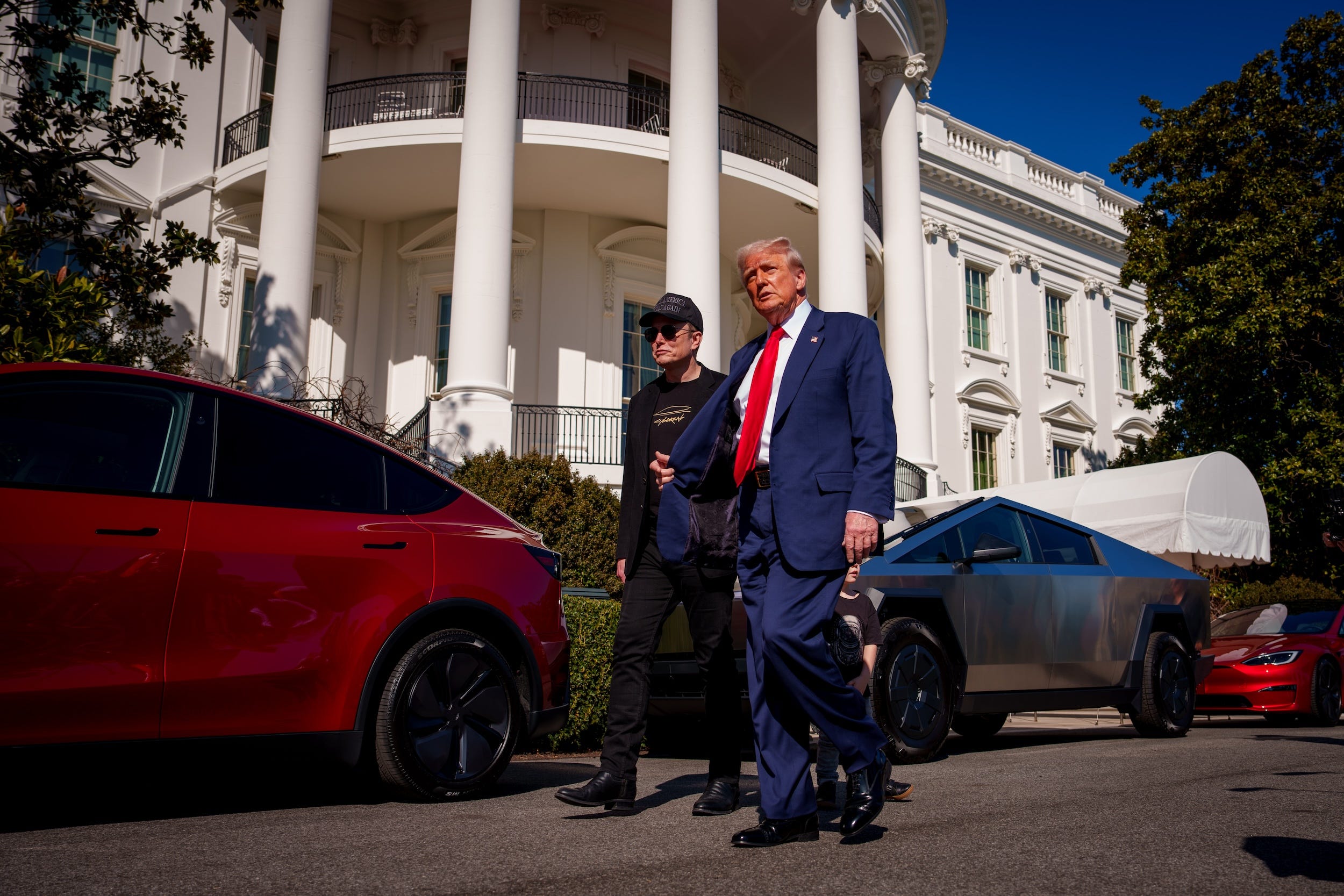 Donald Trump and Elon Musk walk outside the White House before Trump talked about Tesla cars