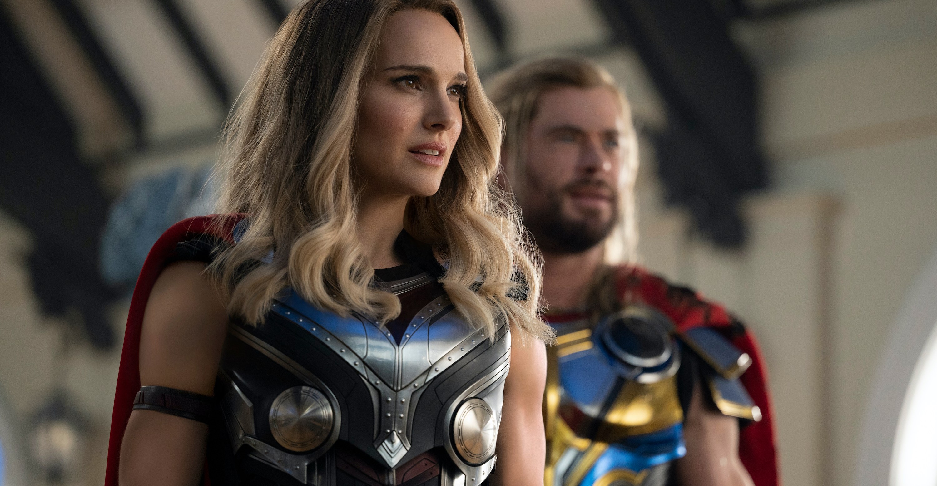 Natalie Portman as The Mighty Thor stands in front of Chris Hemsworth as Thor in Thor: Love and Thunder