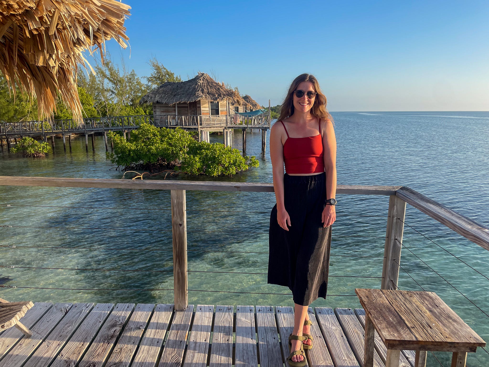 The author on the deck of her overwater bungalow at Thatch Caye Resort in Belize.