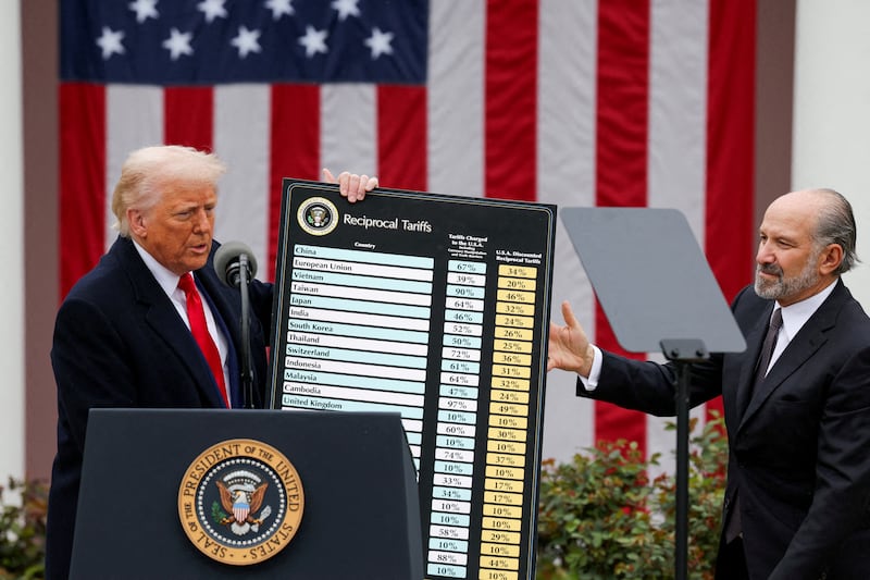 U.S. President Donald Trump holds a chart next to U.S. Secretary of Commerce Howard Lutnick as Trump delivers remarks on tariffs in the Rose Garden at the White House in Washington, D.C., U.S., April 2, 2025.