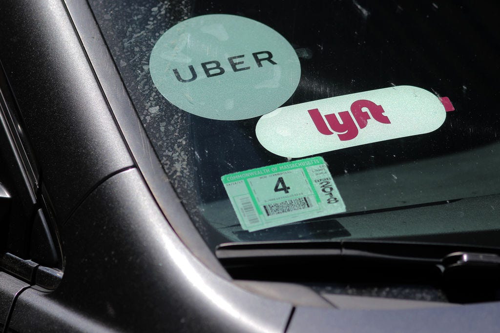 Uber and Lyft signs on a car