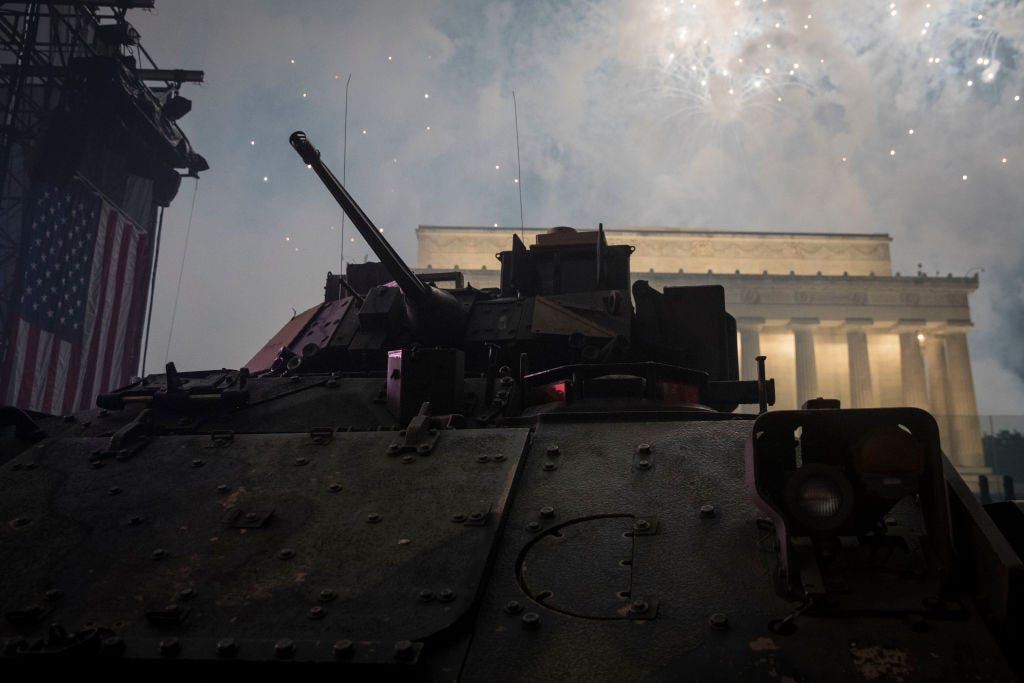 A Bradley fighting vehicle at the earlier Salute to America celebration. Fireworks are going off in the background.