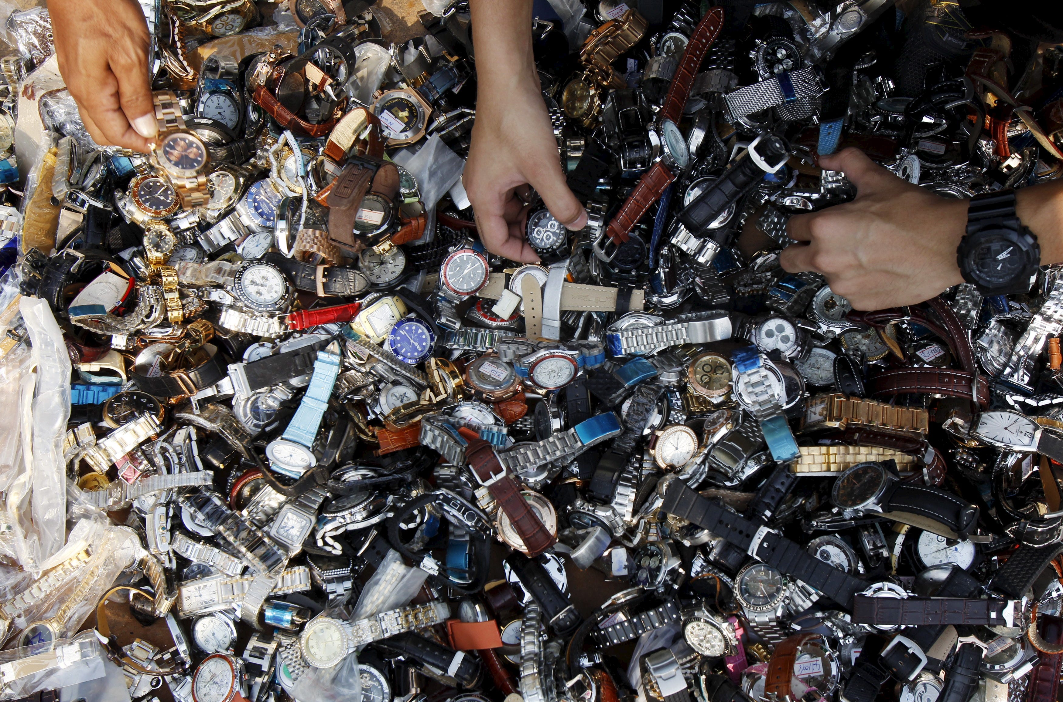 hands digging through a pile of watches