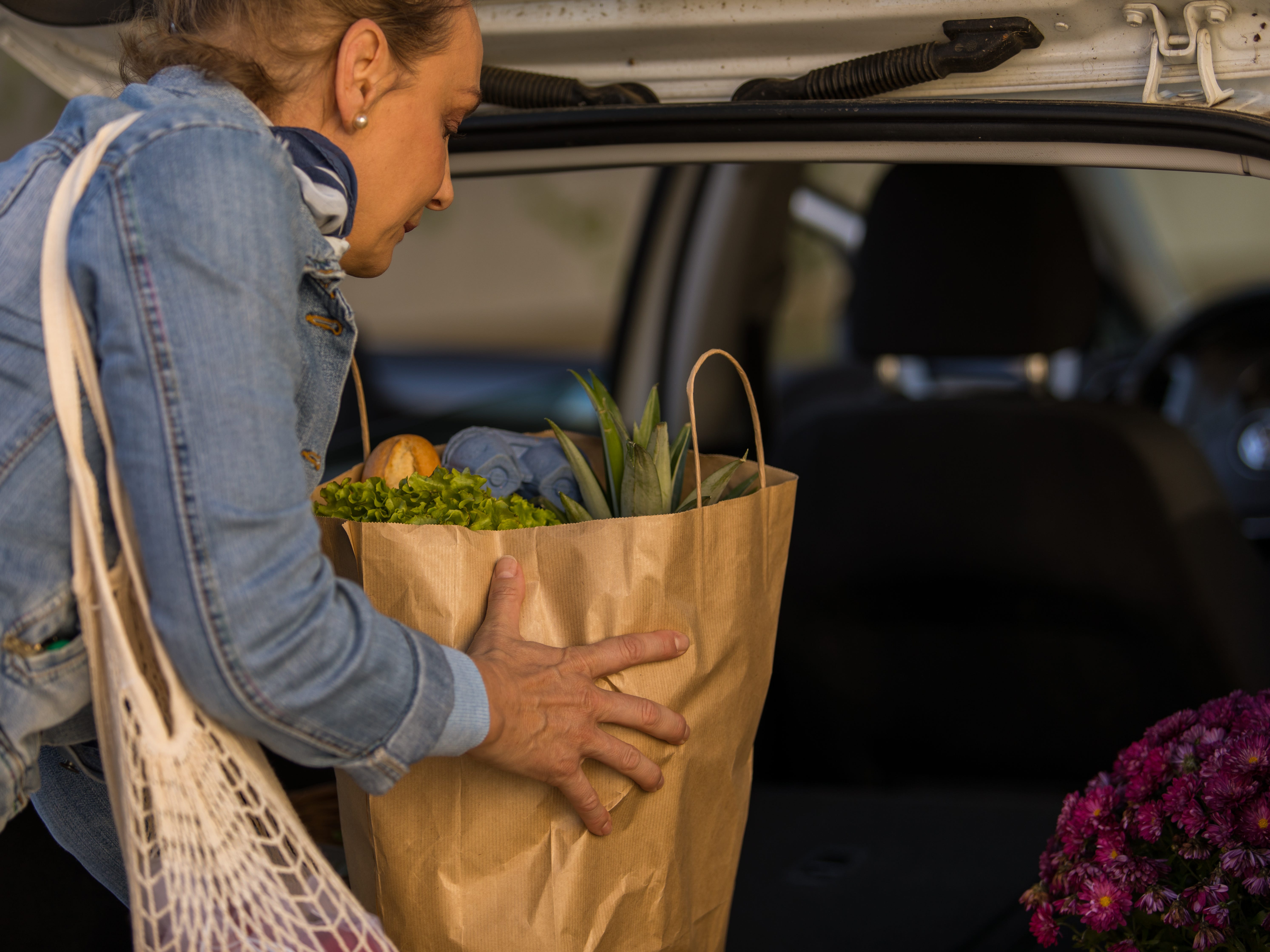 a woman lading her car up with groceries