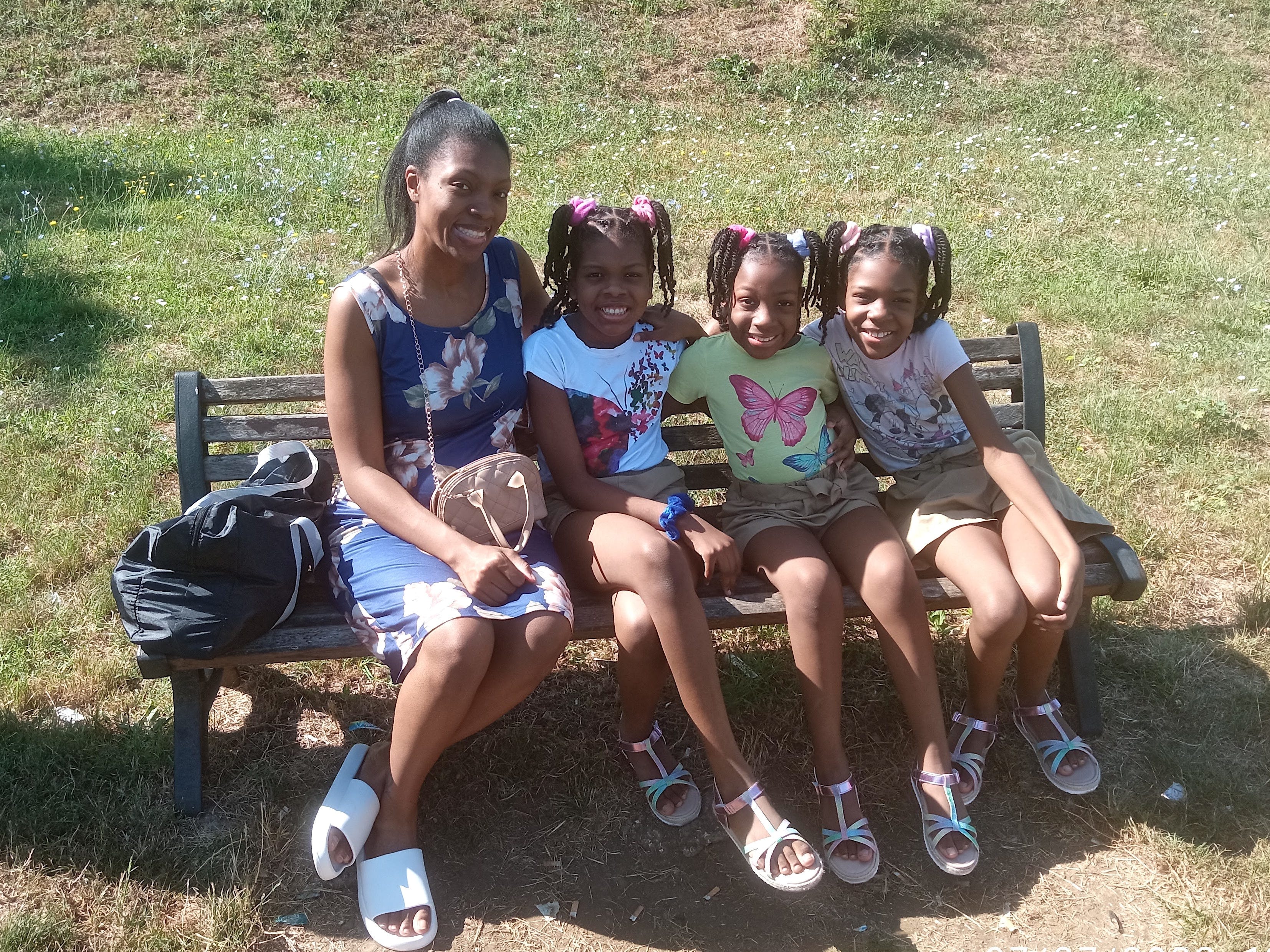 The author sitting with her three girls on a park bench.