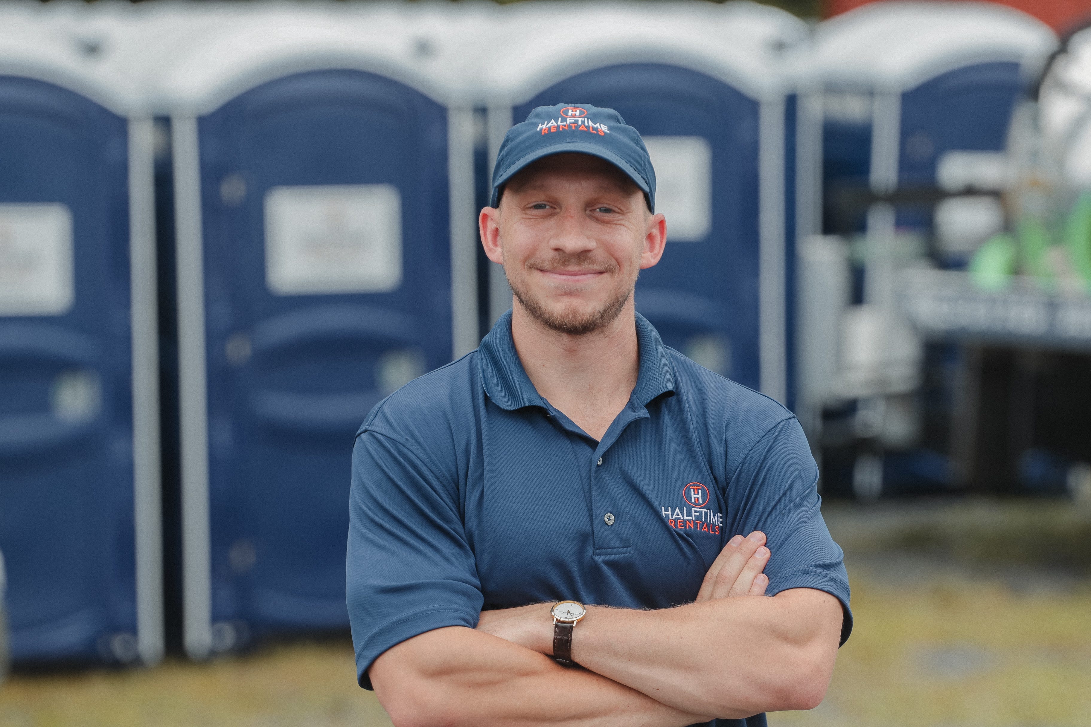 Man in Halftime Rentals great stands in front of portapotties