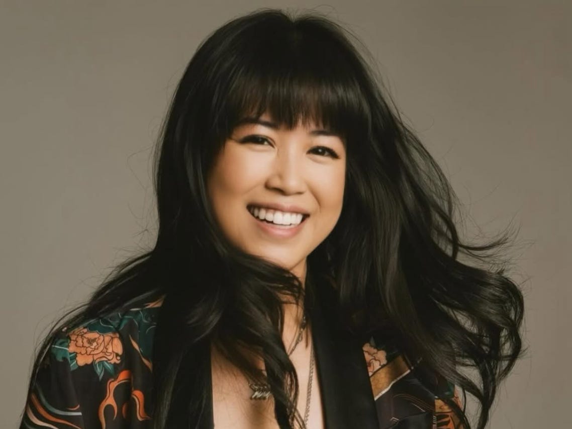 headshot of a woman with black hair on a brown background