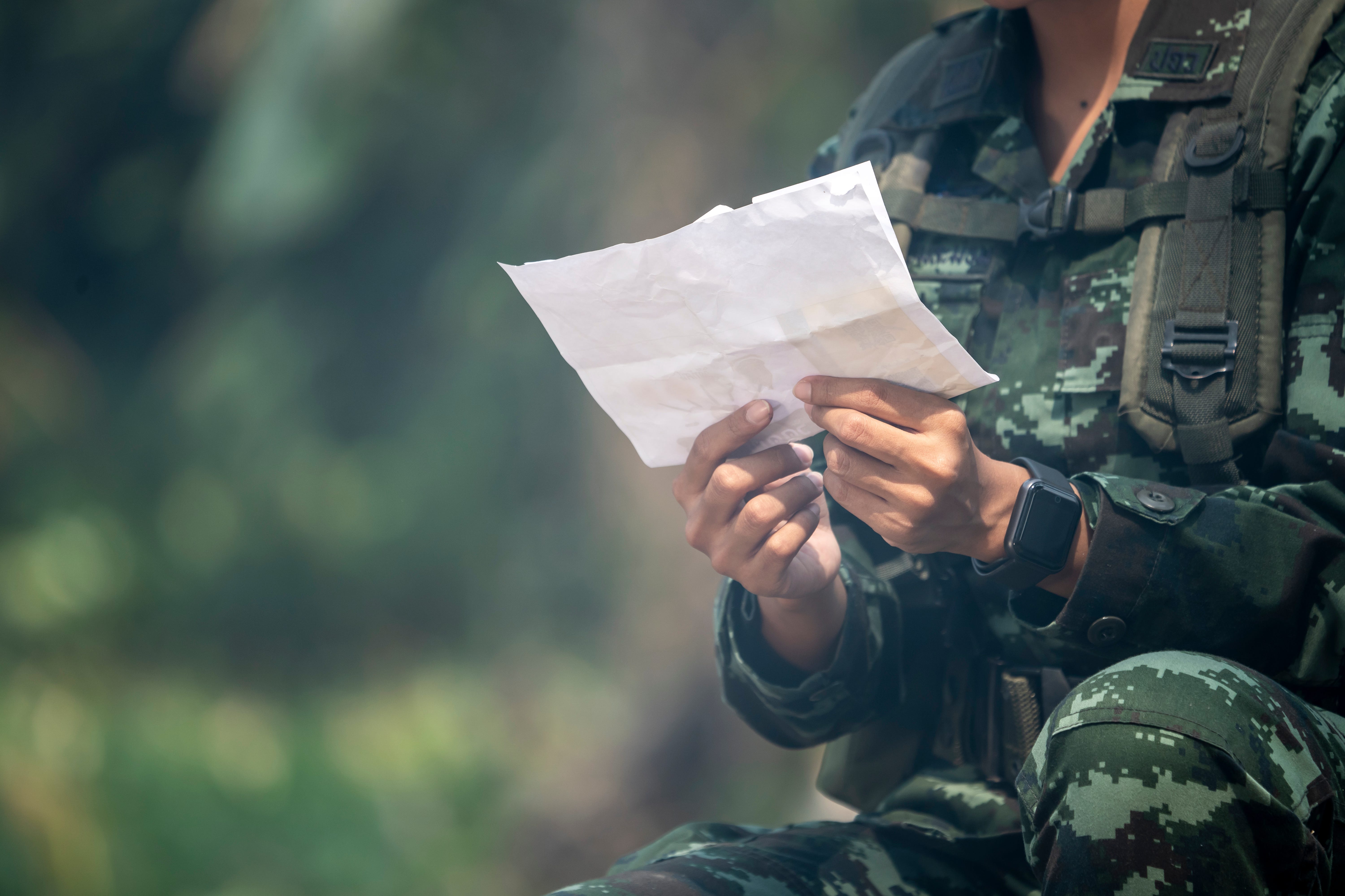 soldier reading letter among war
