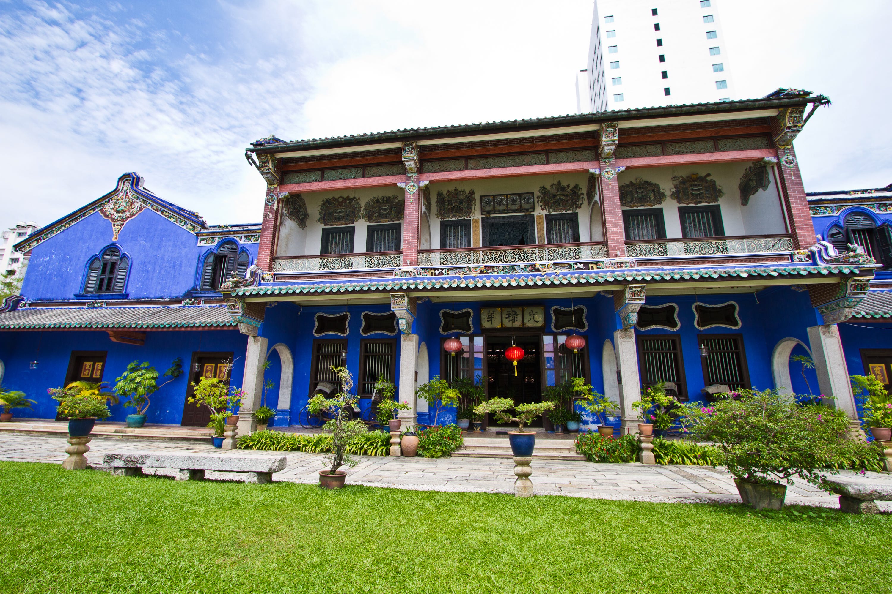 Cheong Fatt Tze, The Blue Mansion in Malaysia with cobalt-blue exterior, covered porch, trees out front