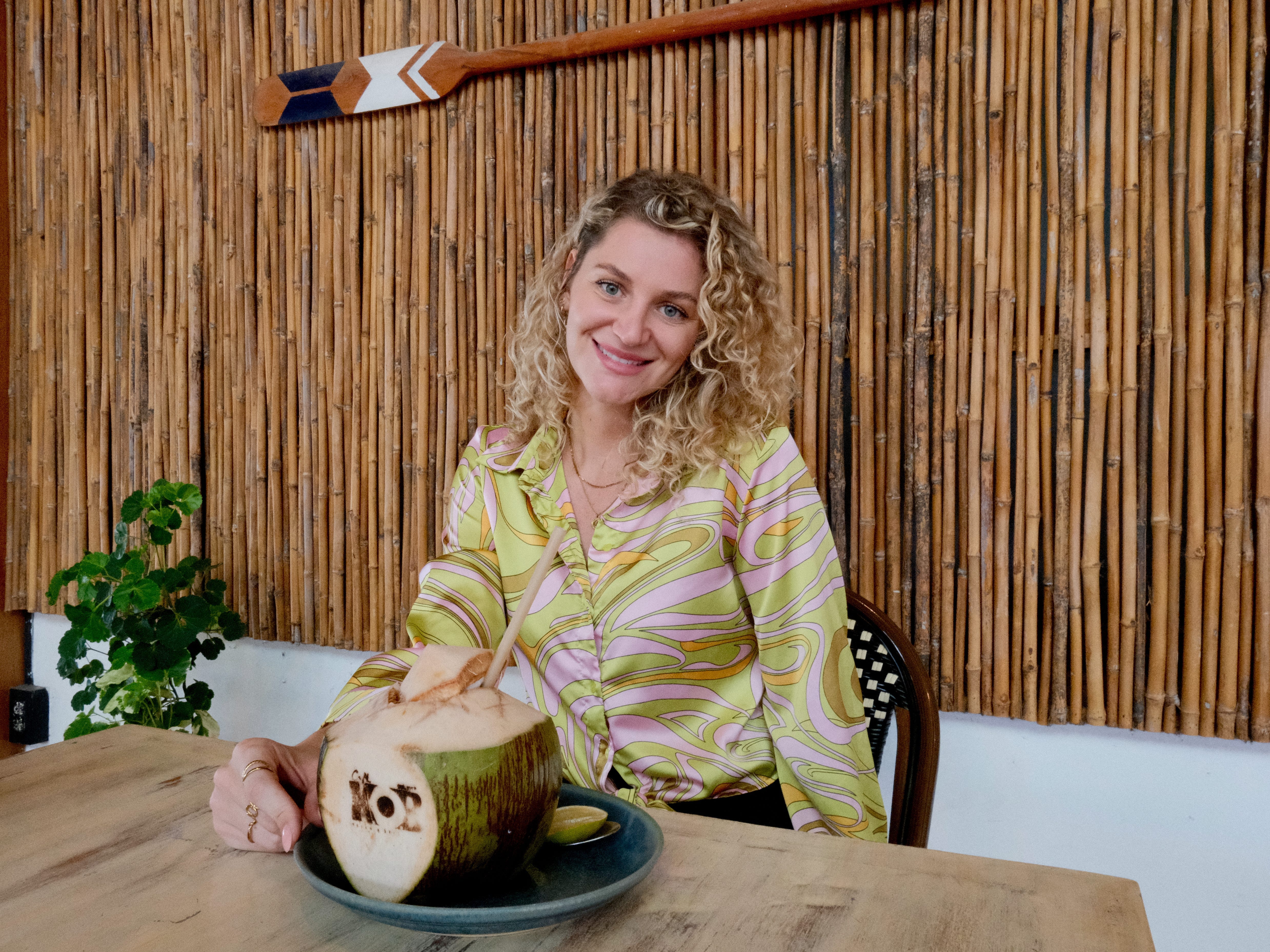 A woman posing with a coconut in a café in Koh Samui, Thailand.