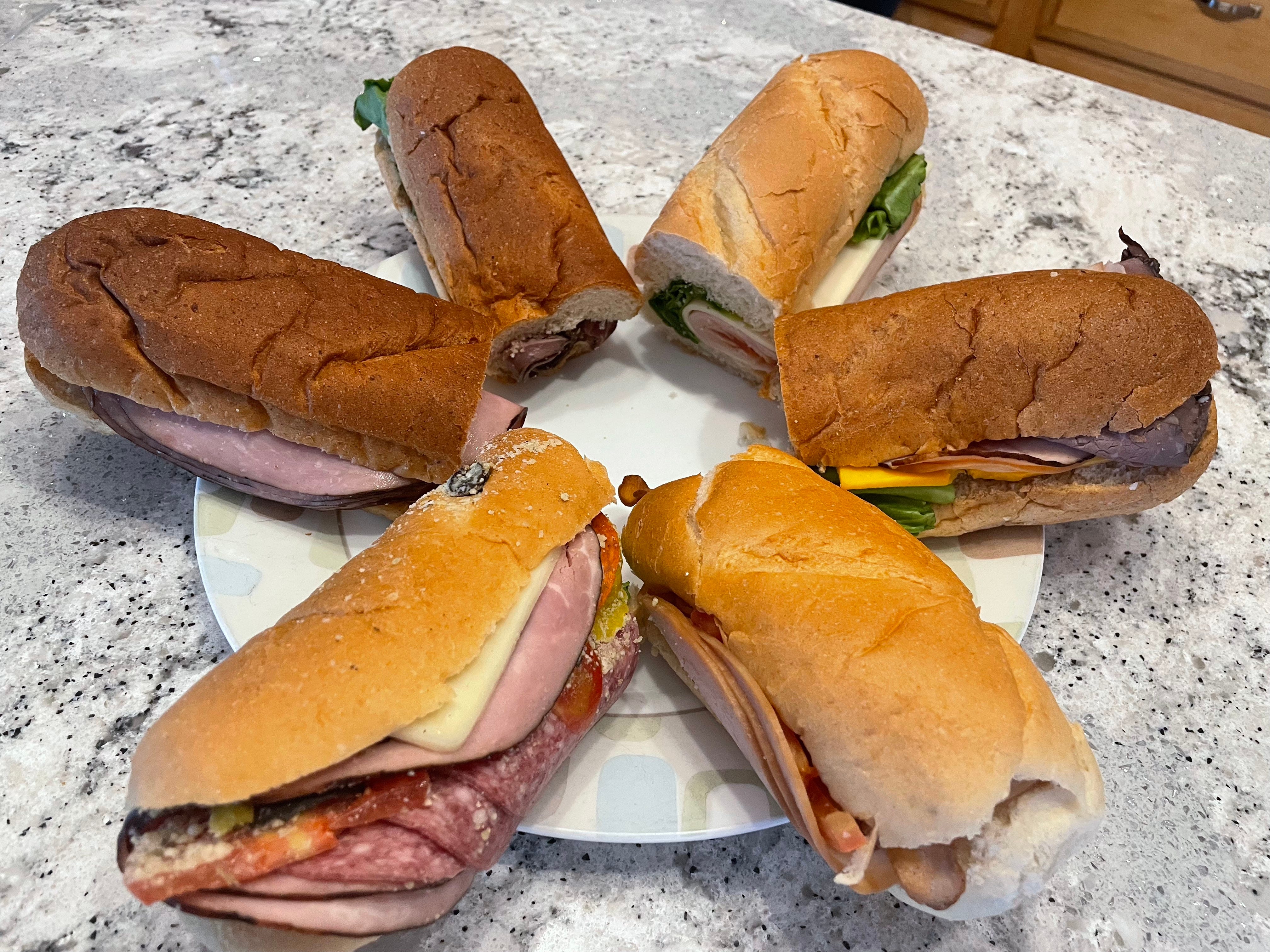 The author's six sub sandwiches from QuikTrip arranged on a plate in a circle.
