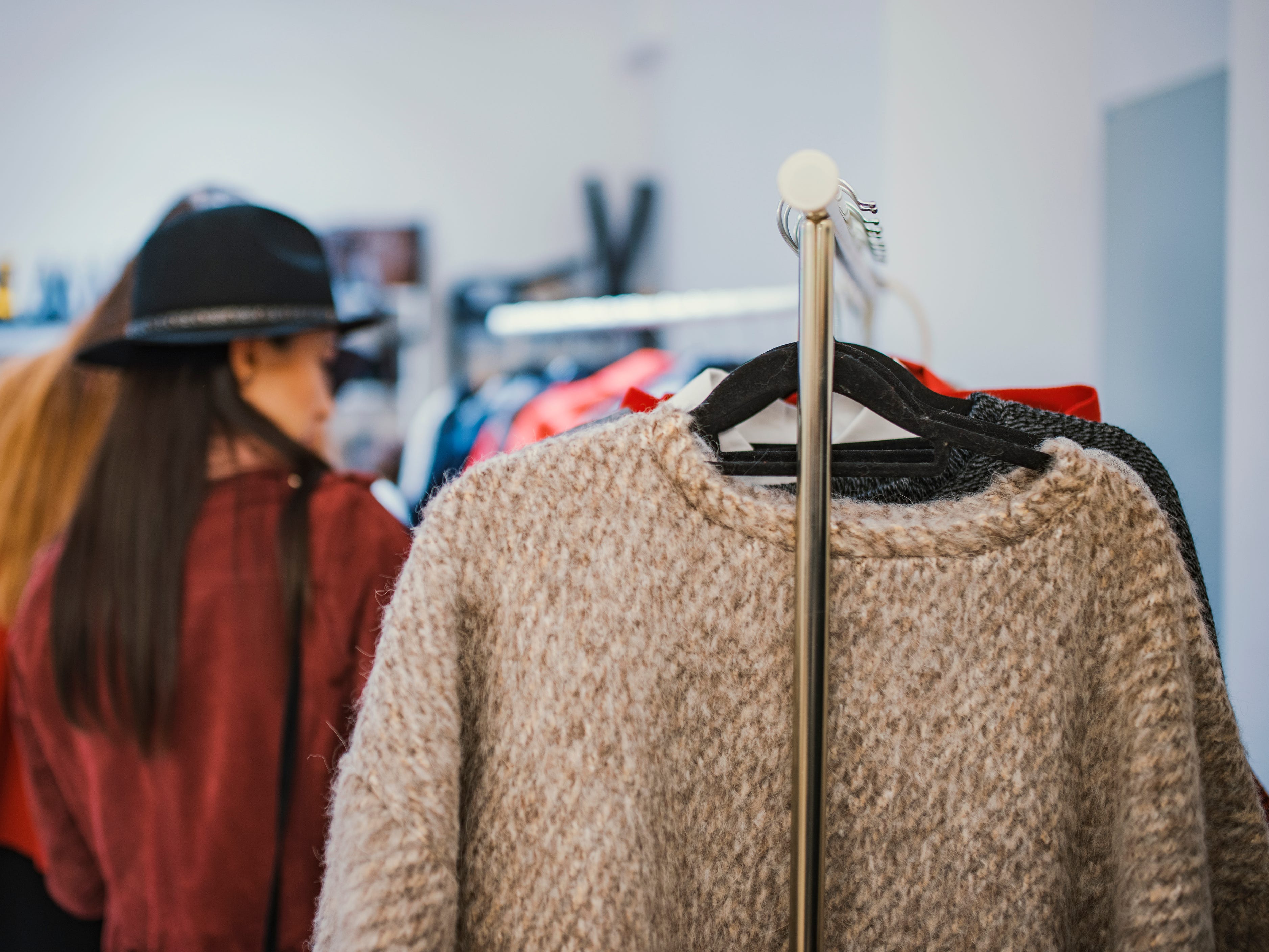 a woman shopping with clothes on a rack