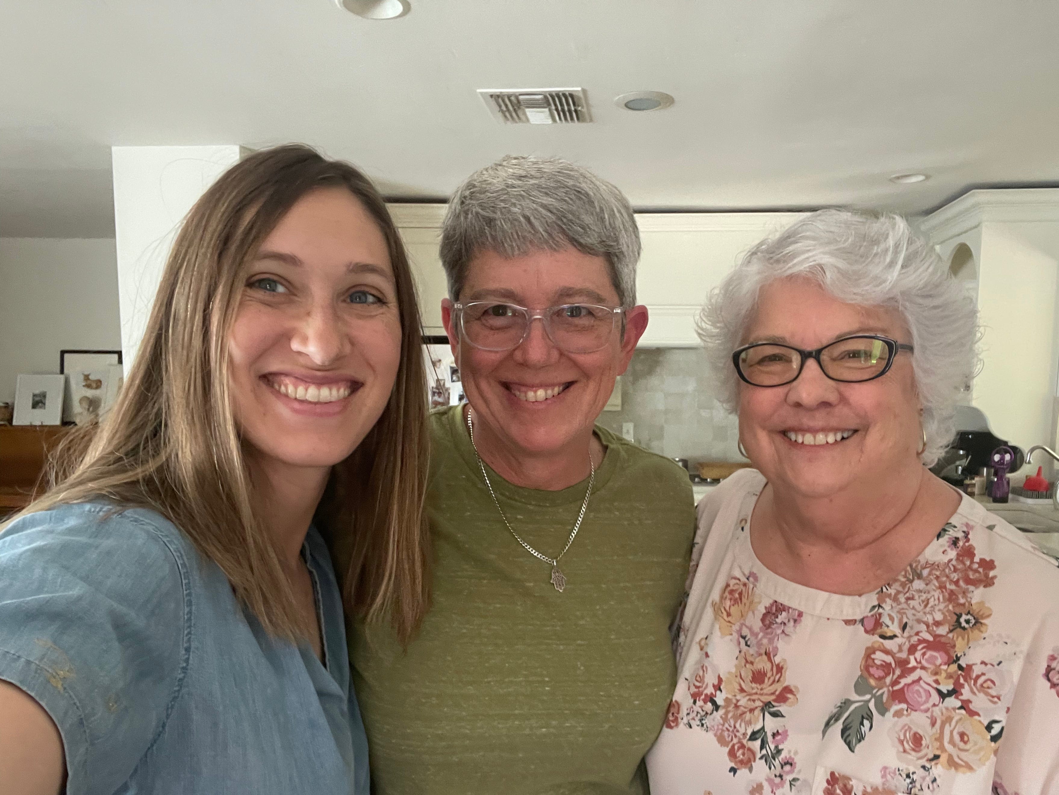 The author and two of her friends smiling at the camera in a kitchen.