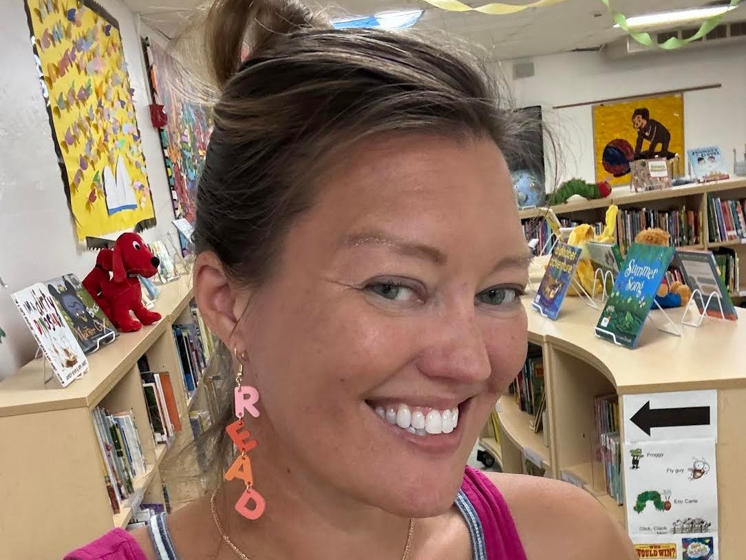 A woman poses inside a school library.