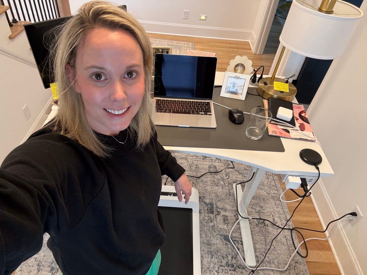 Author Elliott Harrell smiling at raised desk while standing on walking pad