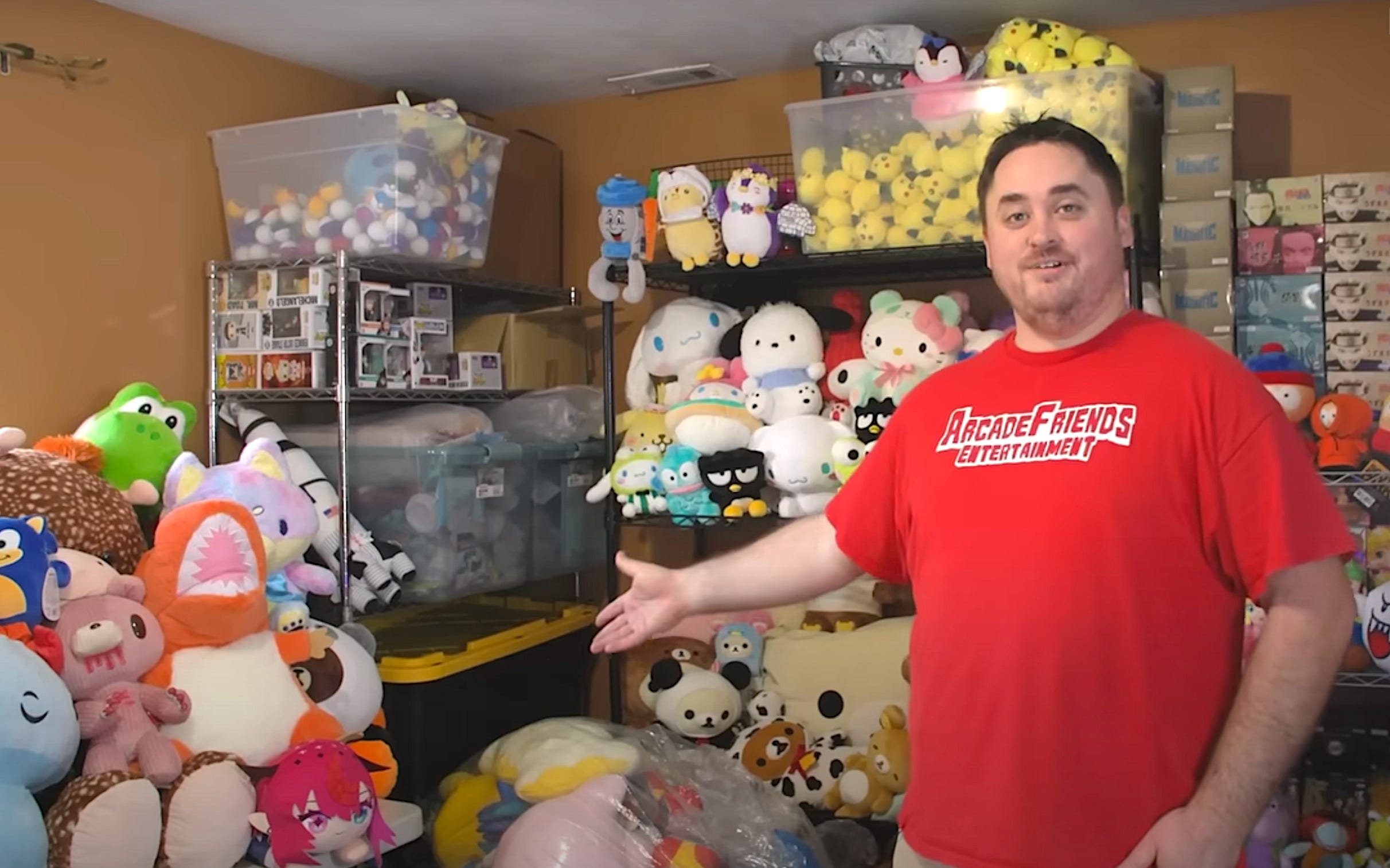 Mike Nay in a room full of plushies he won