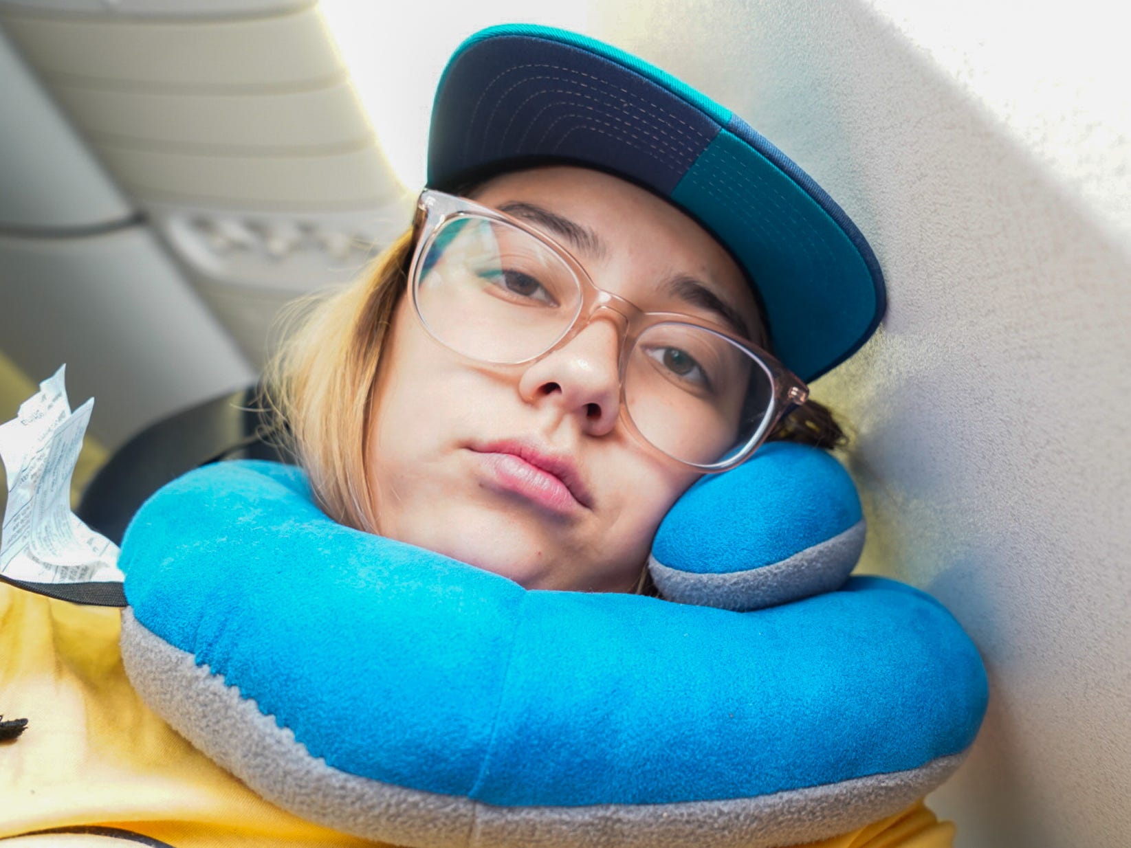 The author rests using a neck pillow on a long-haul flight
