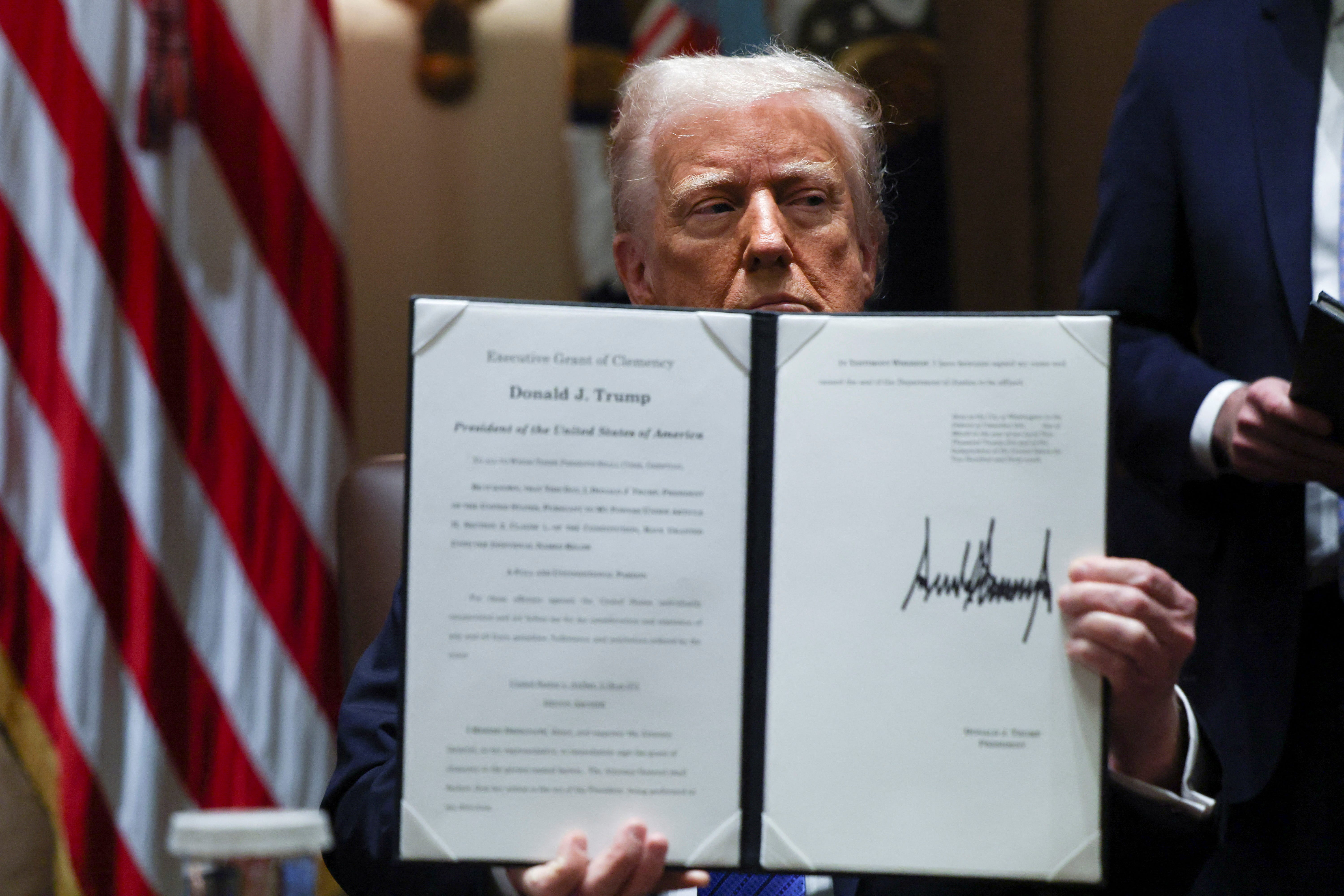 U.S. President Donald Trump holds an Executive order.