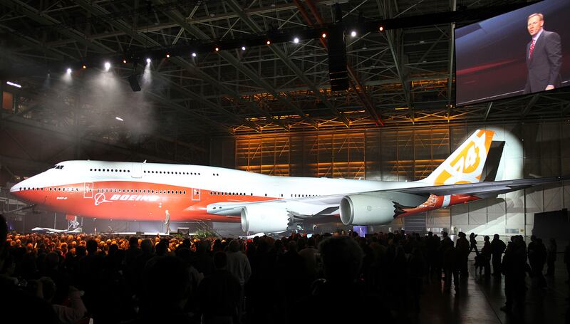 Boeing raises a curtain to unveil the 747-8 jumbo passenger jet to thousands of employees and guests at the company's Everett, Washington commercial airplane manufacturing facility, February 13, 2011. Boeing vice president and general manager of Boeing's Commercial Airplanes airplane program Pat Shanahan is pictured on the jumbo screen in the upper right as he officiated the ceremony. Boeing Co rolled out the new jumbo jet on Sunday, hoping to relive the glamor surrounding the birth of the 747 over 40 years ago and use it to boost slow sales. REUTERS/Anthony Bolante (UNITED STATES - Tags: TRANSPORT BUSINESS)
