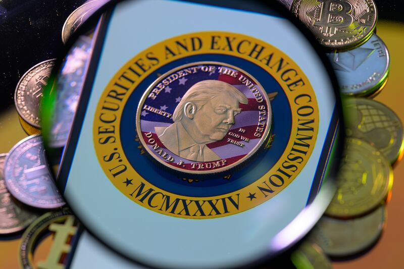 This photo illustration shows a representation of cryptocracy coins with the $Trump meme coin.