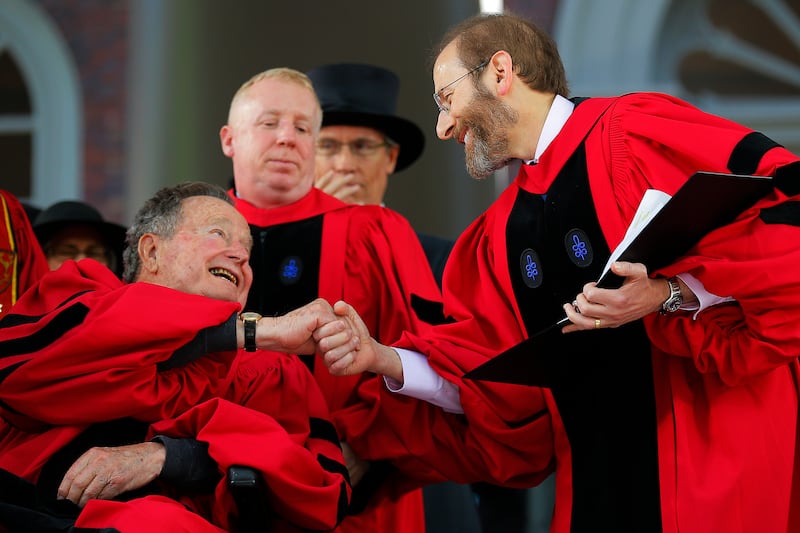 Former U.S. president George H. W. Bush (L) shakes hands with Provost Alan Garber as he receives an honorary Doctor of Laws degree at Harvard on May 29, 2014. Garber is now Harvard University’s president and has pushed back against President Donald Trump’s demands in recent months.