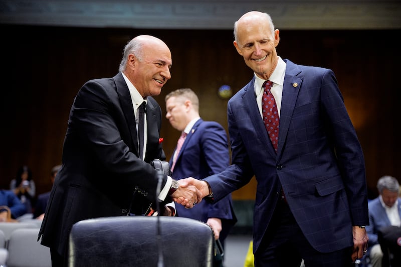 Businessman Kevin O'Leary, 70, greets Republican Sen. Rick Scott of Florida before he spoke in front of a Senate Committee on April 9. He has been a staunch supporter of President Donald Trump.