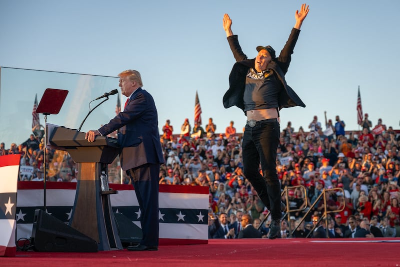 Elon Musk (Right) jumps on stage as he joins former Donald Trump during a campaign rally.