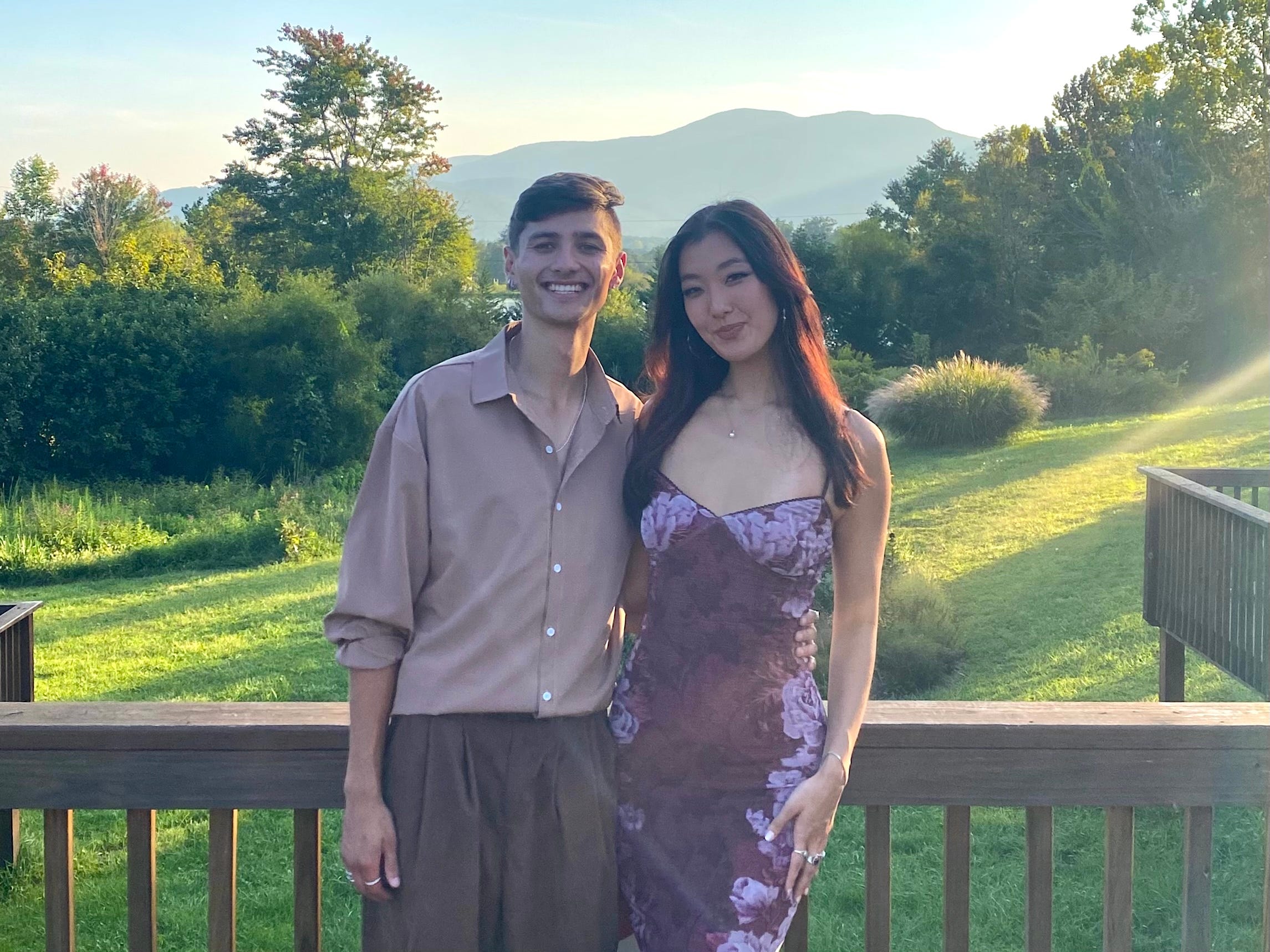 The author and her boyfriend standing on a balcony over a grassy field.
