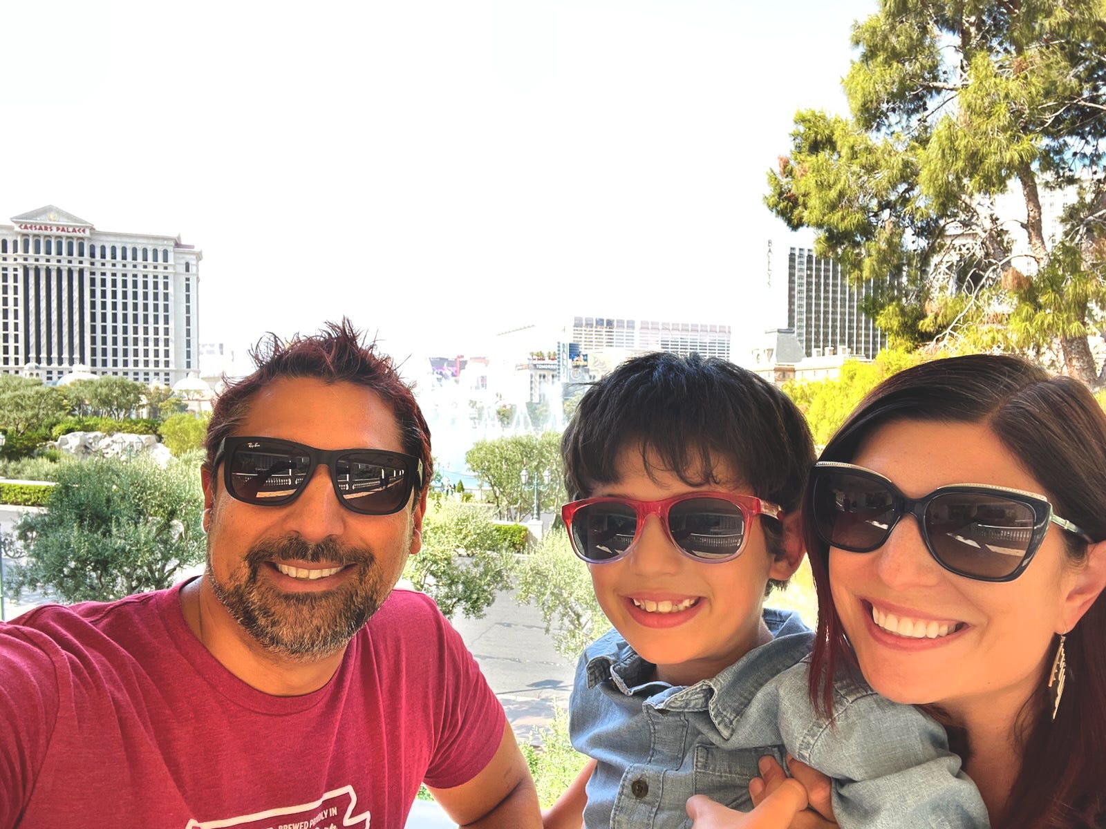 Author Amanda Adler, her son, and husband smiling with sunglasses on in Las Vegas