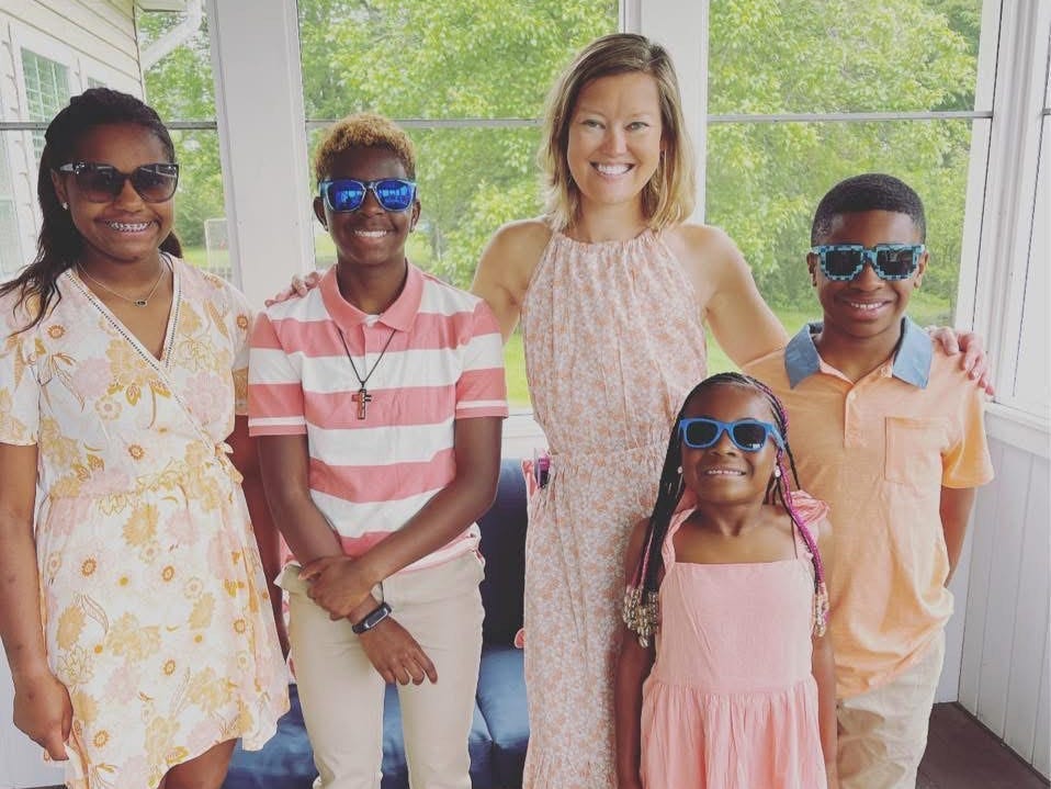 A woman poses with her four children.