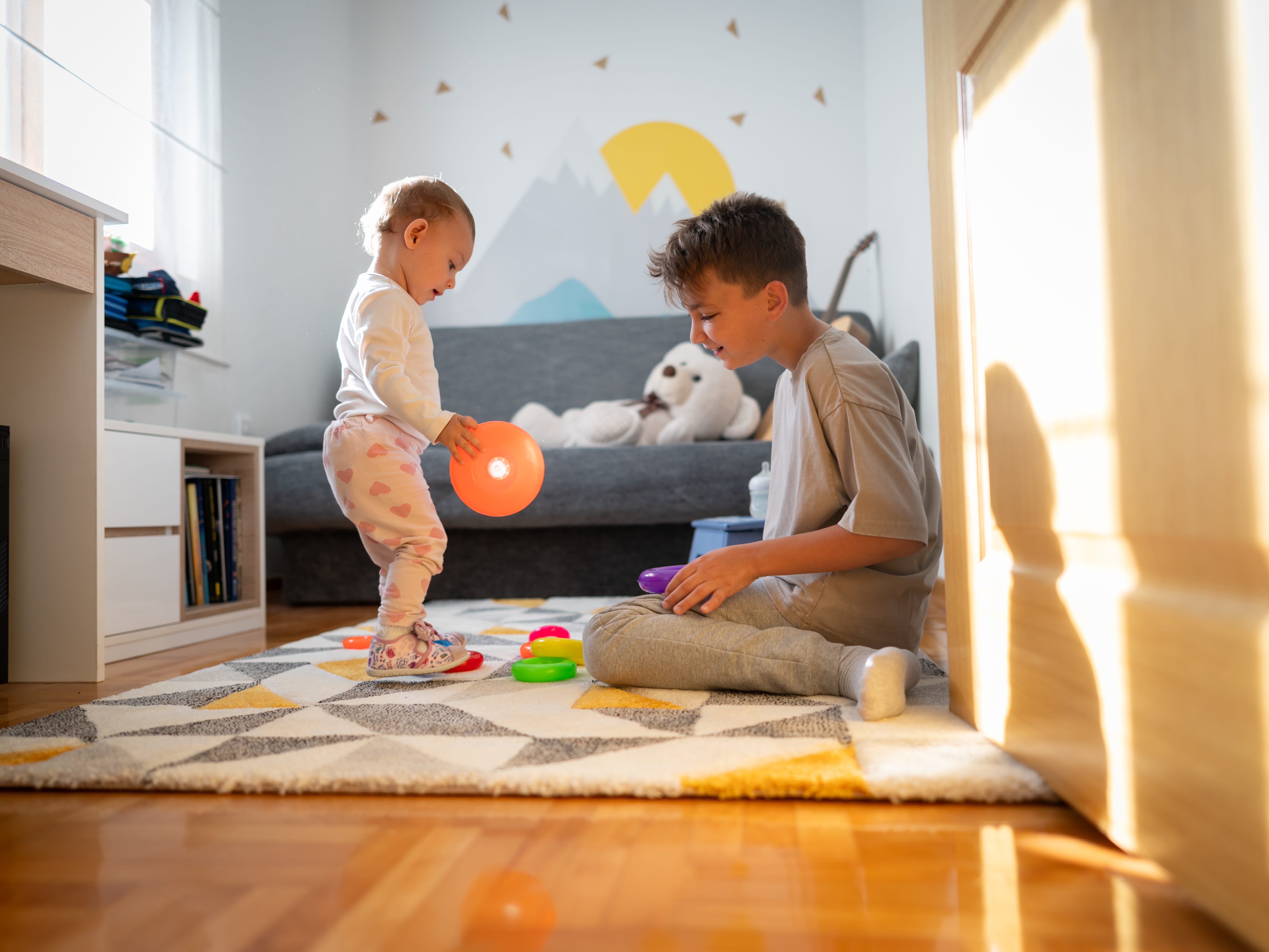 Older Brother and Baby sister playing with toys